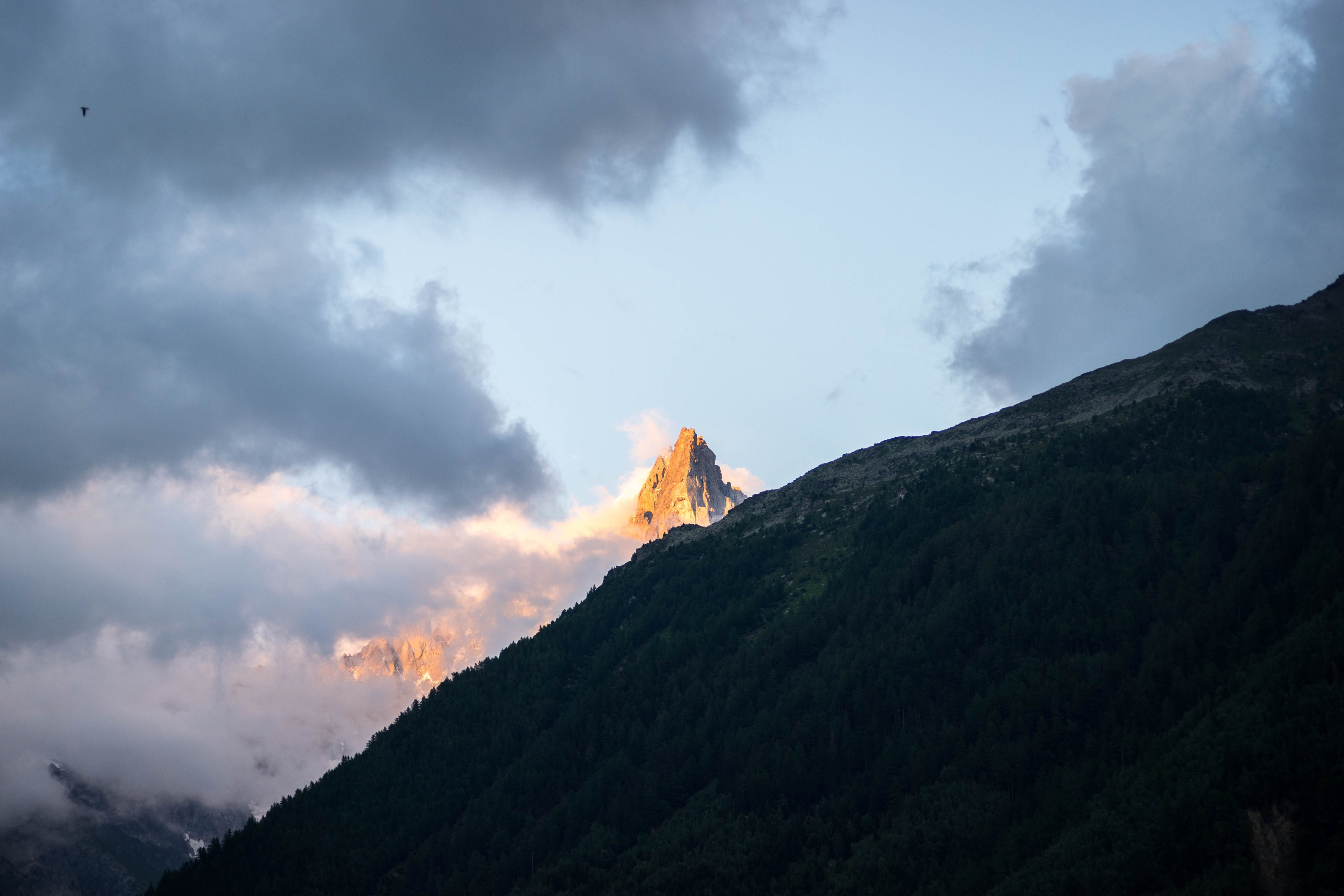 sunlit mountain peak behind clouds in chamonix, sunset hitting a peak 4k, HD Wallpaper