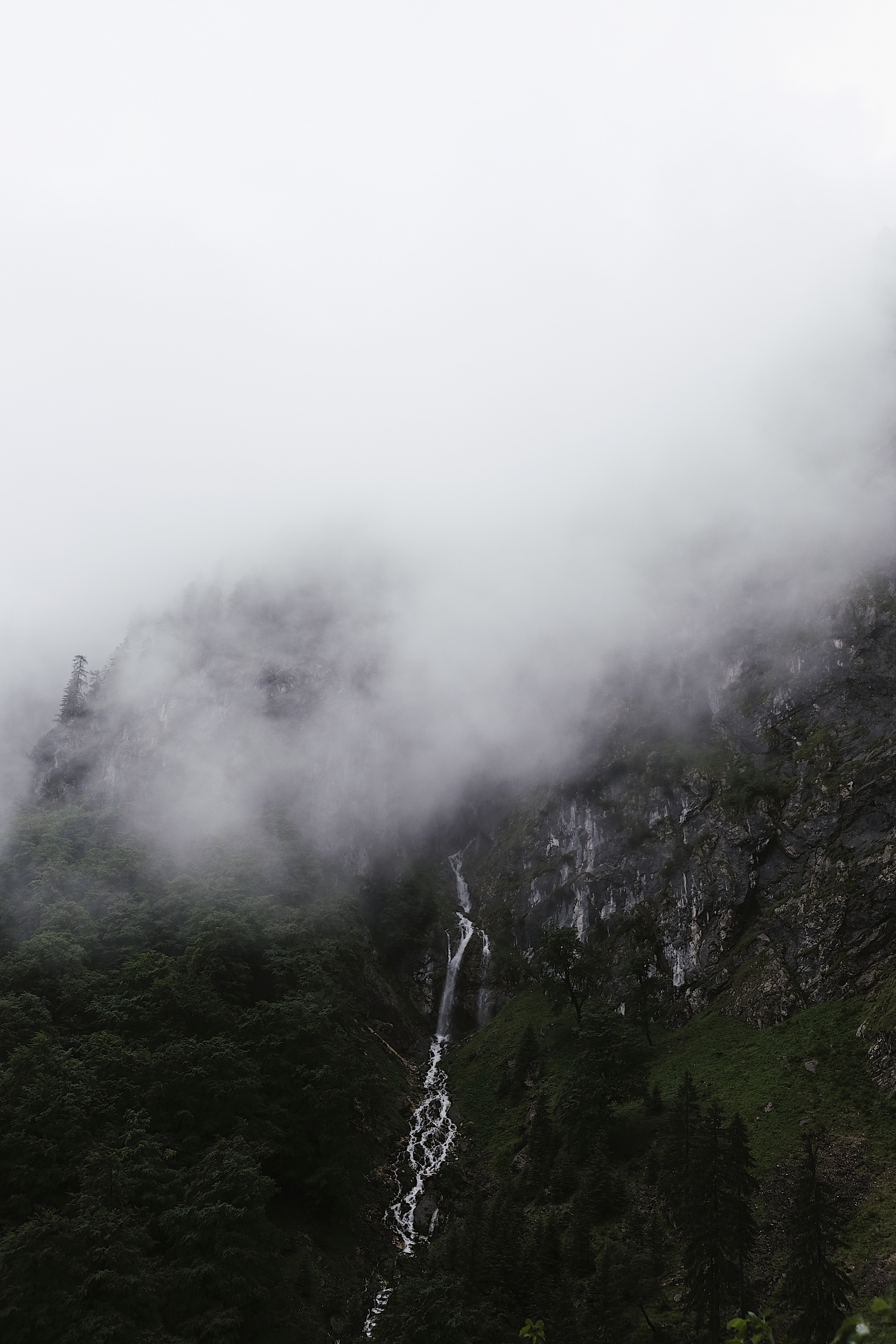 waterfall cascades down a rocky mountainside through the mist in zugspitze, waterfall in the mountains 4k, Phone HD Wallpaper