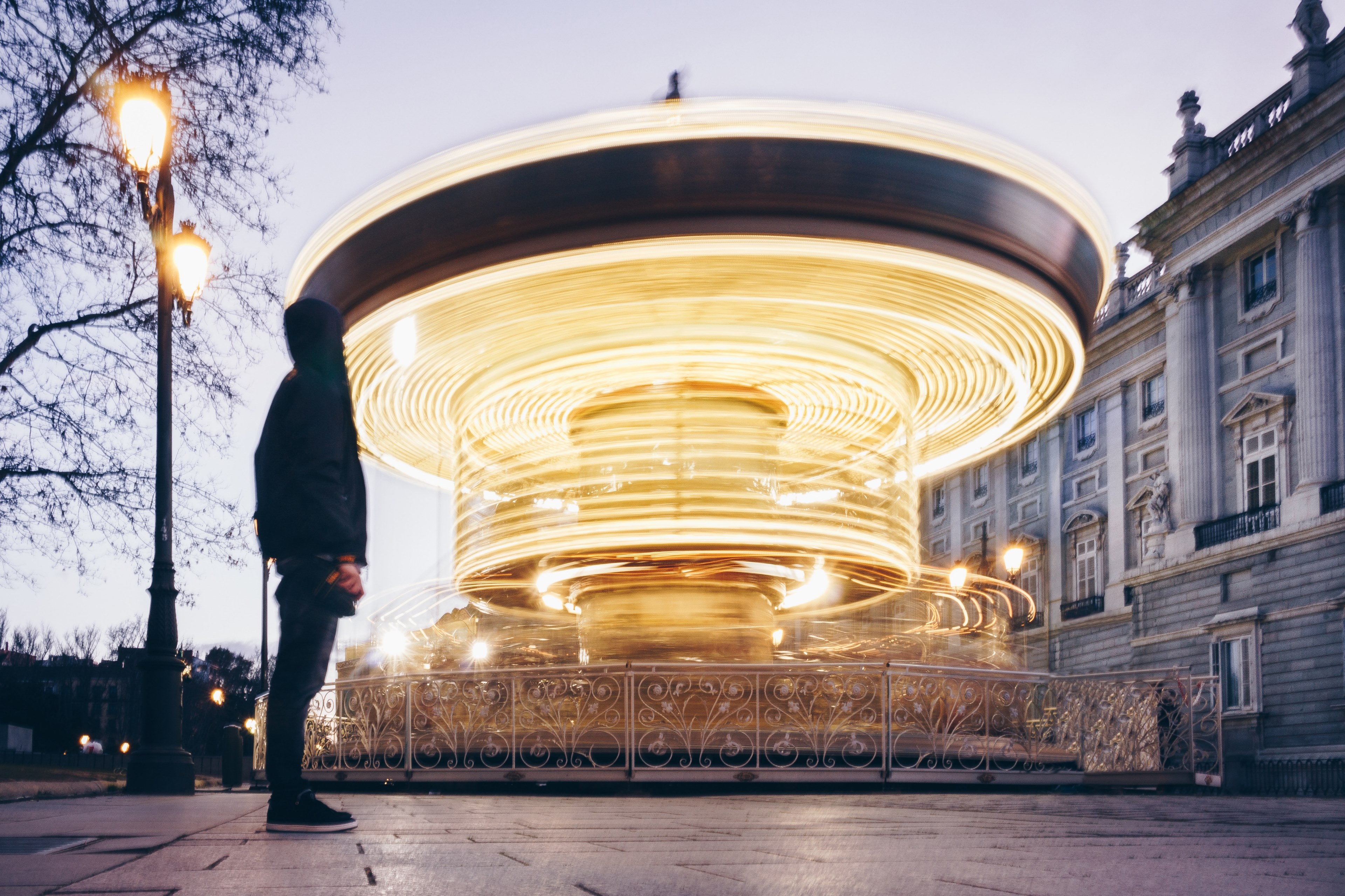 a person standing in front of the royal palace of madrid with spinning lights around a structure, spinning lights in a static world 4k, HD Wallpaper