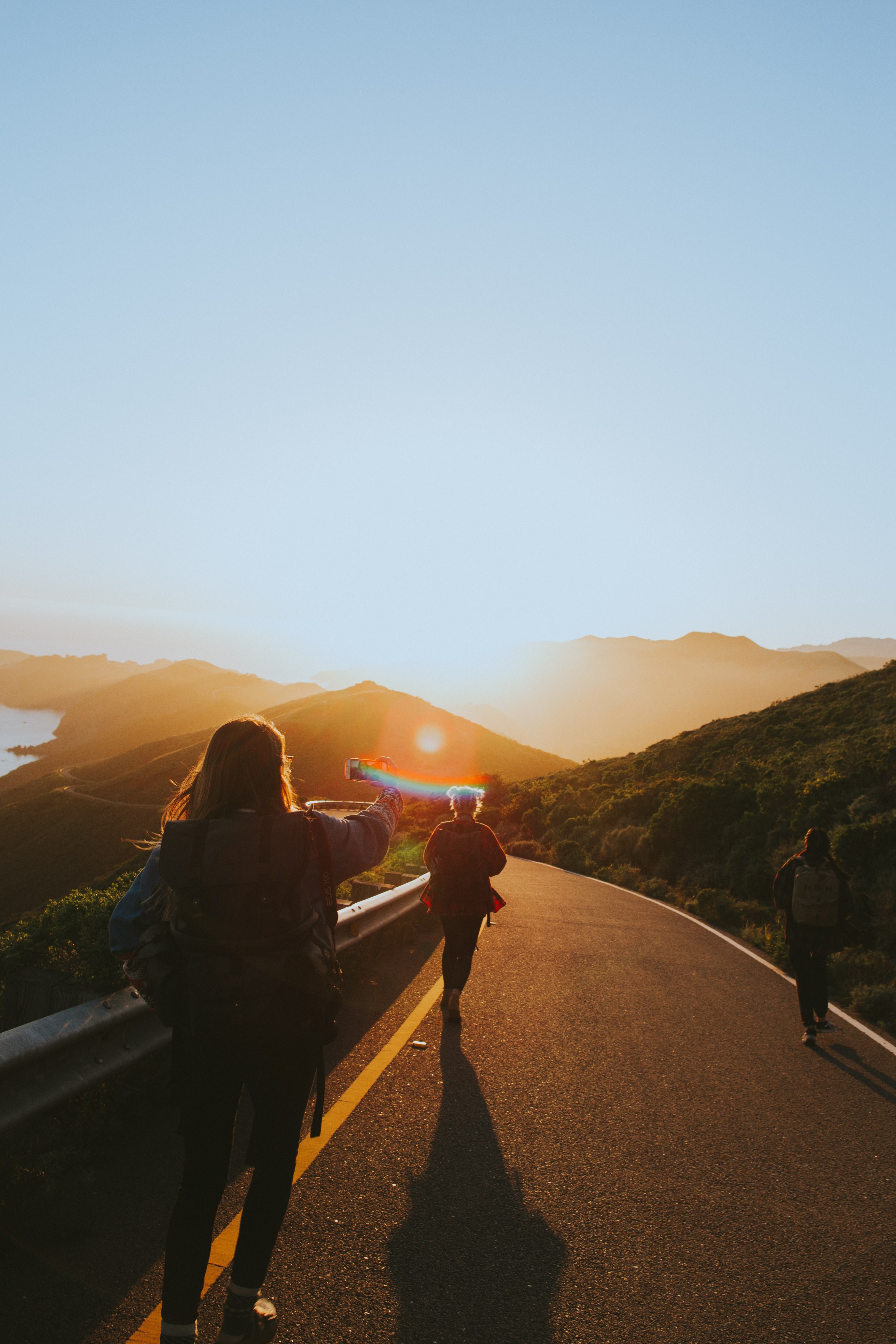 people walking down a hill while one of them takes a selfie on their cellphone during sunset, friends and sunsets 4k, Phone HD Wallpaper