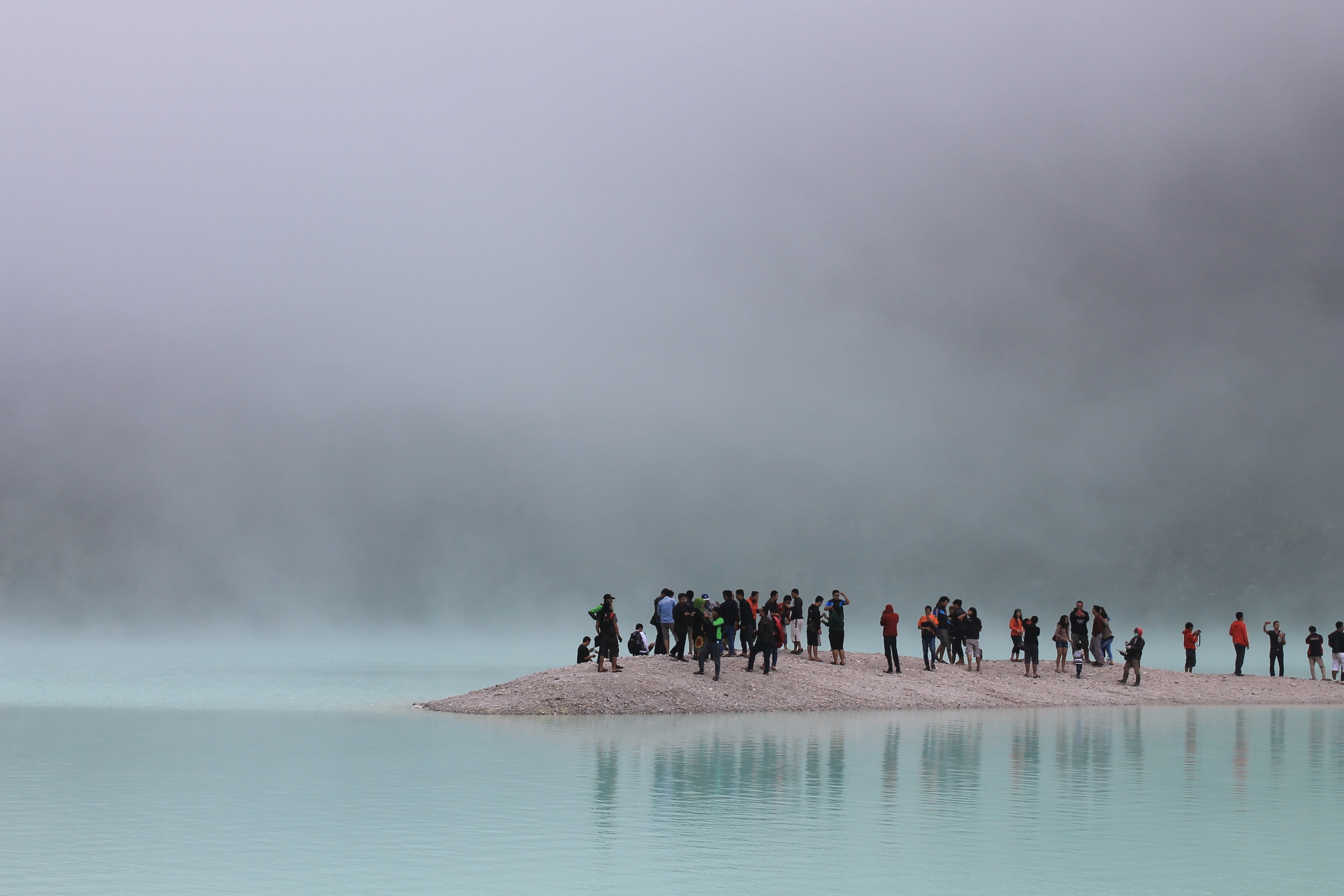 diverse group of tourists stand on a peninsula on a foggy day, sightseeing on the beach 4k, HD Wallpaper