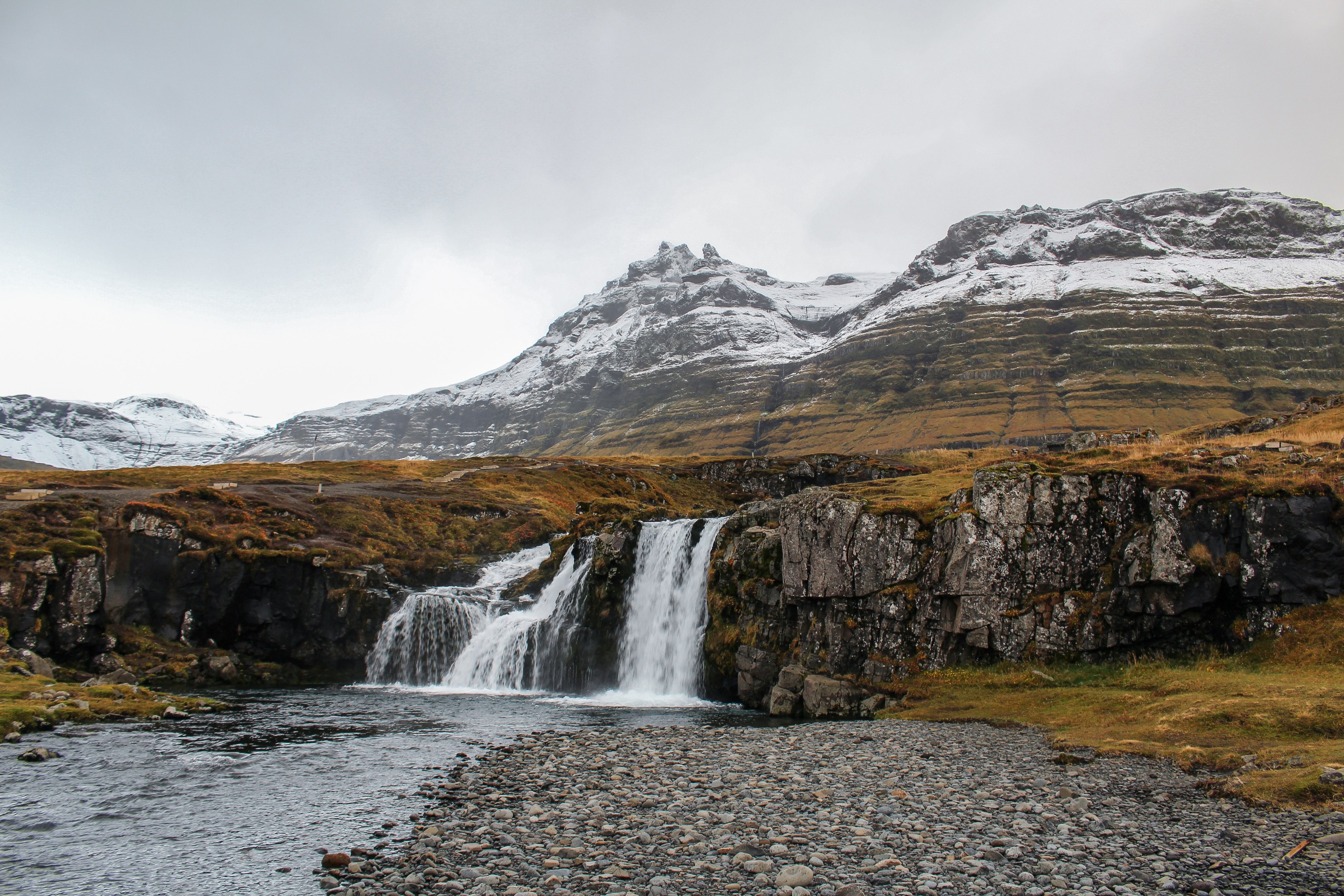 a waterfall pouring down from a rocky plateau with steep mountains at the back, waterfall in iceland 4k, HD Wallpaper