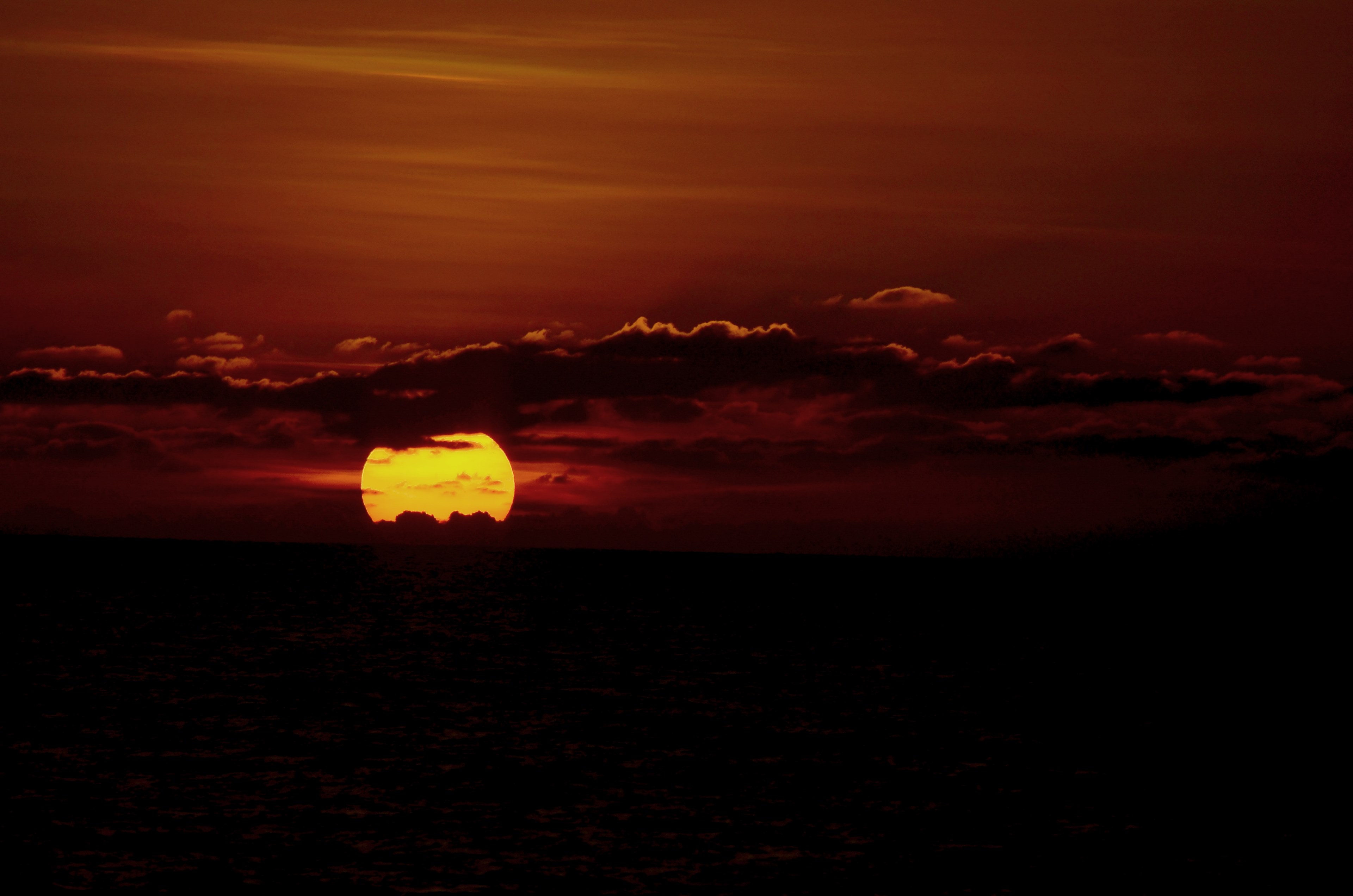 the golden sun resting on the horizon coloring the sky and clouds orange in colombo, when the sun has set no candle can replace it 4k, HD Wallpaper