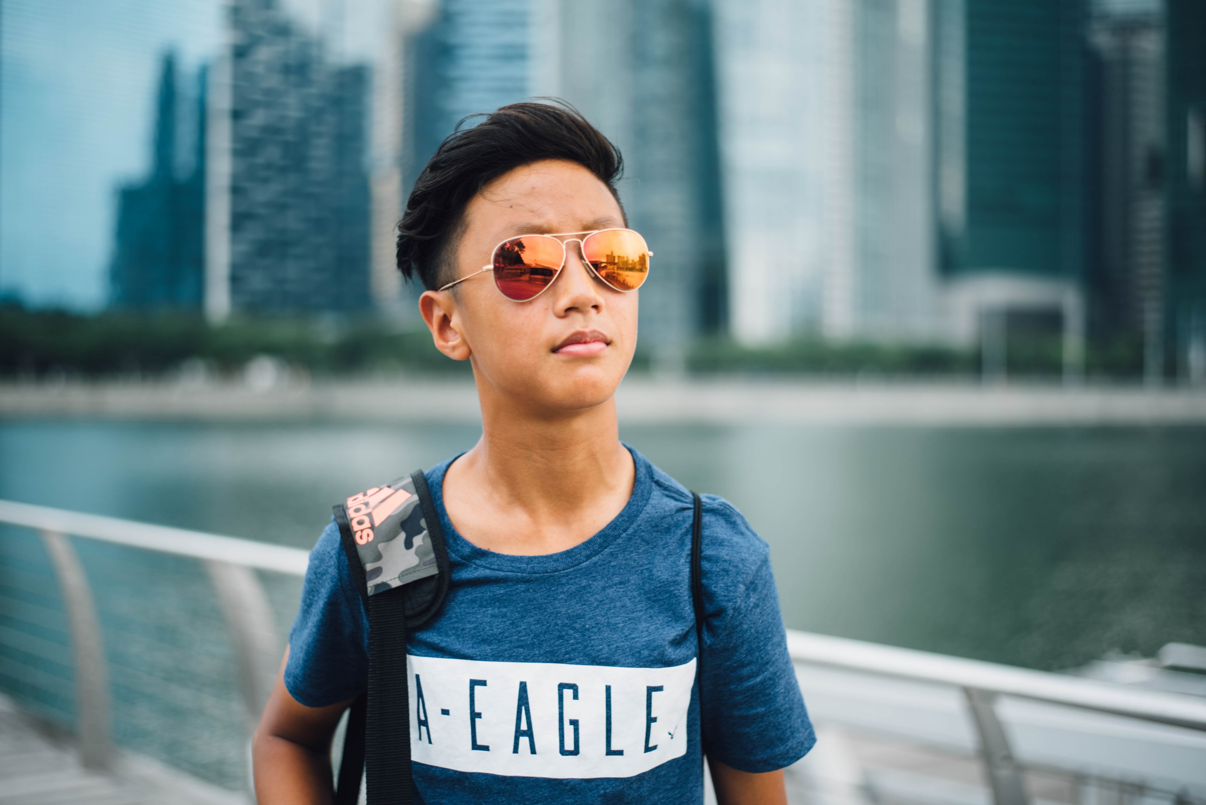 a man in sunglasses looks into the distance with skyscrapers and a river in the background, man with skyscrapers and river 4k, HD Wallpaper