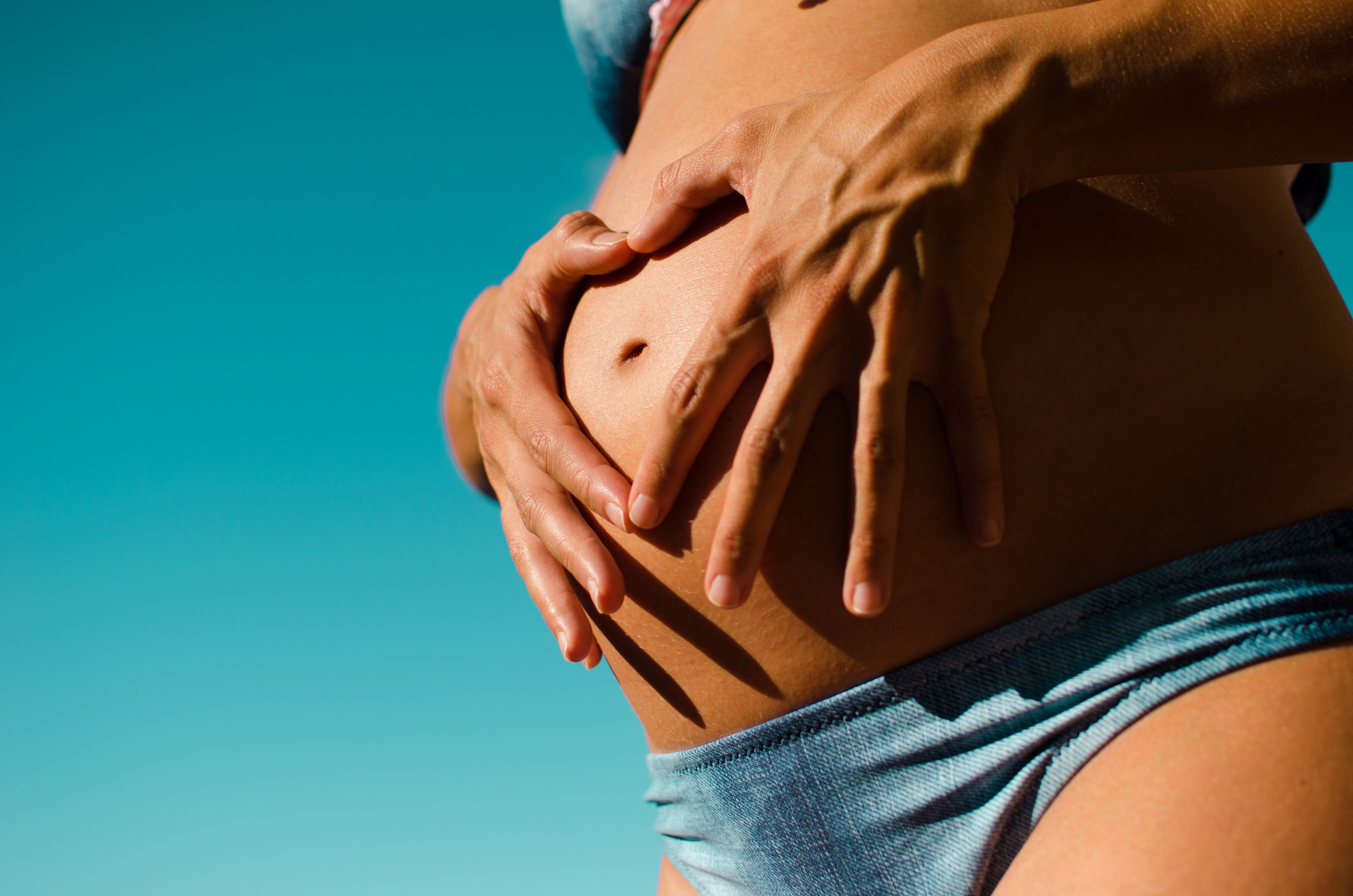 a woman in bikini makes a heart with her fingers placing them over her pregnant belly, pregnancy 4k, HD Wallpaper
