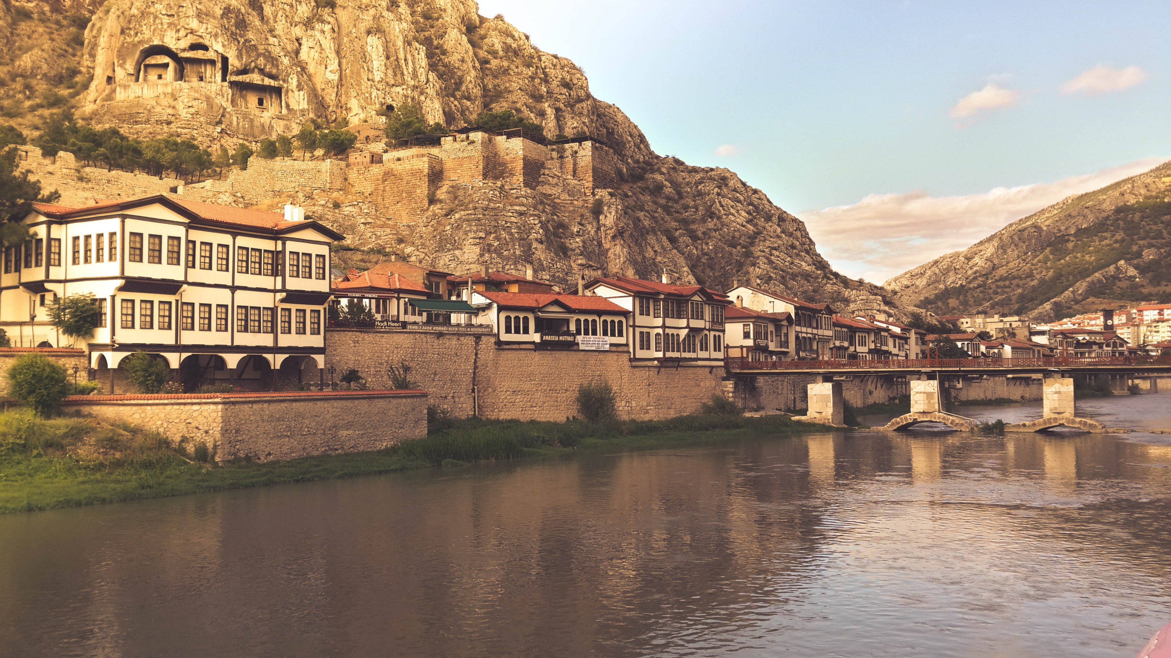 a village by a walled edge in between a rocky mountain area and a river at dusk, small river village 4k, HD Wallpaper