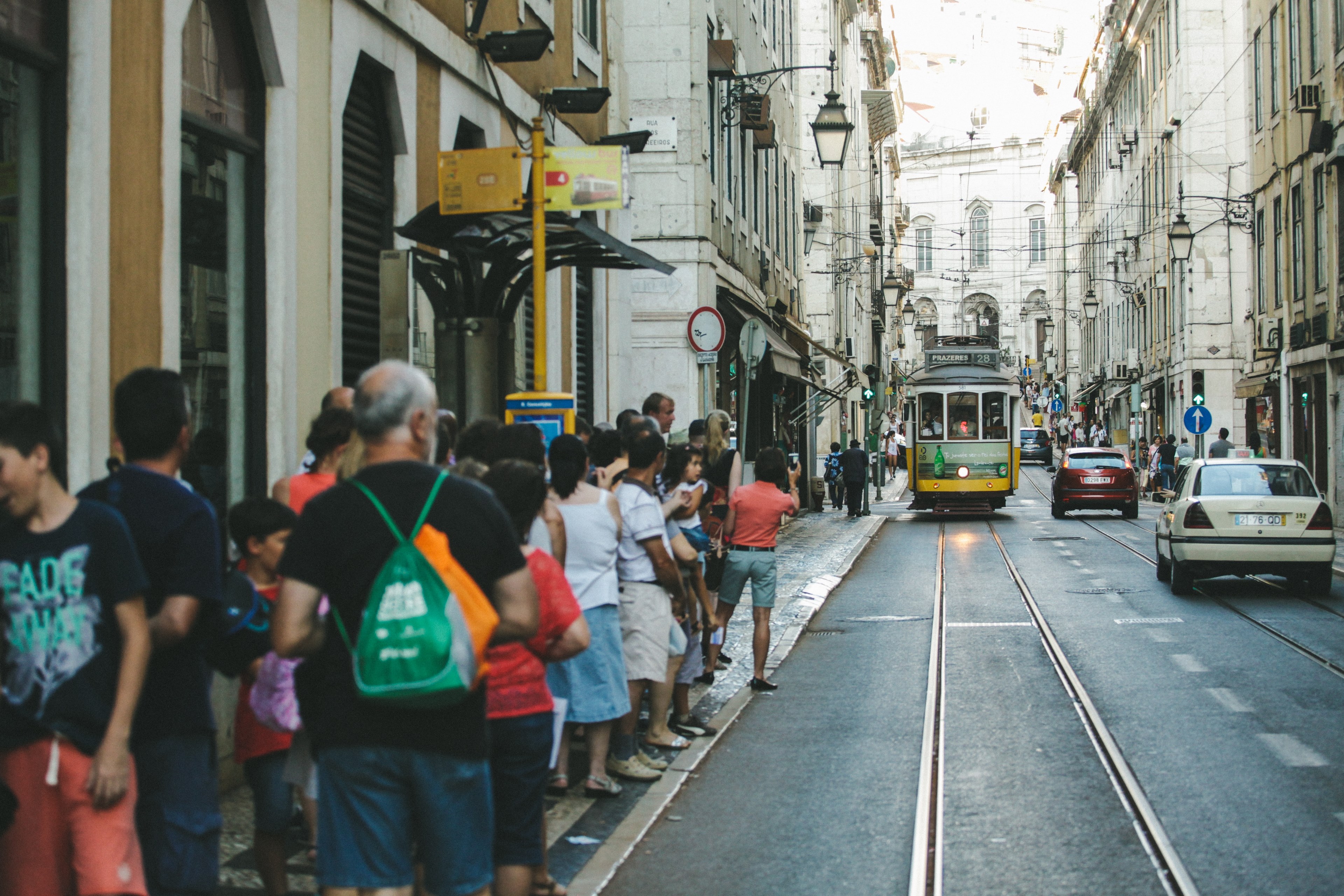 people lining up on the sidewalk as a trolley car approaches the stop, waiting at the trolley stop 4k, HD Wallpaper