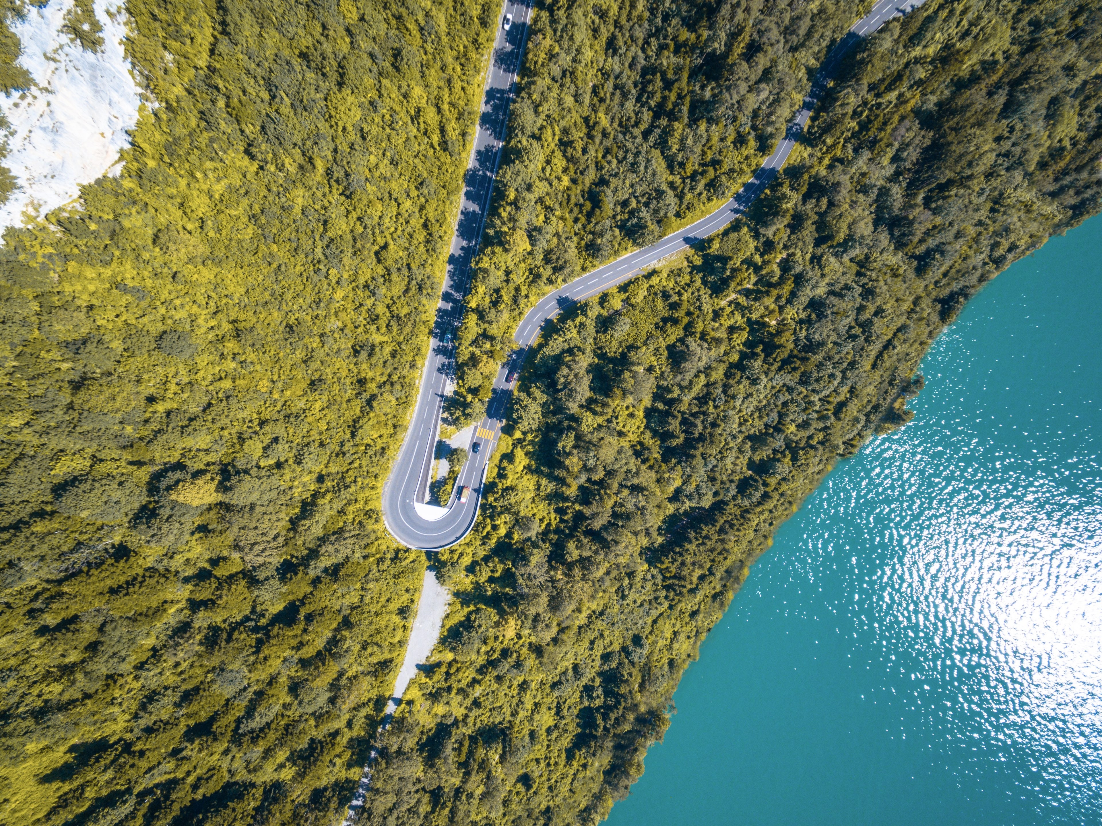 a drone shot of a sharp curve in a road along a shore of a lake in morschach, aerial view of a lakeside road 4k, HD Wallpaper