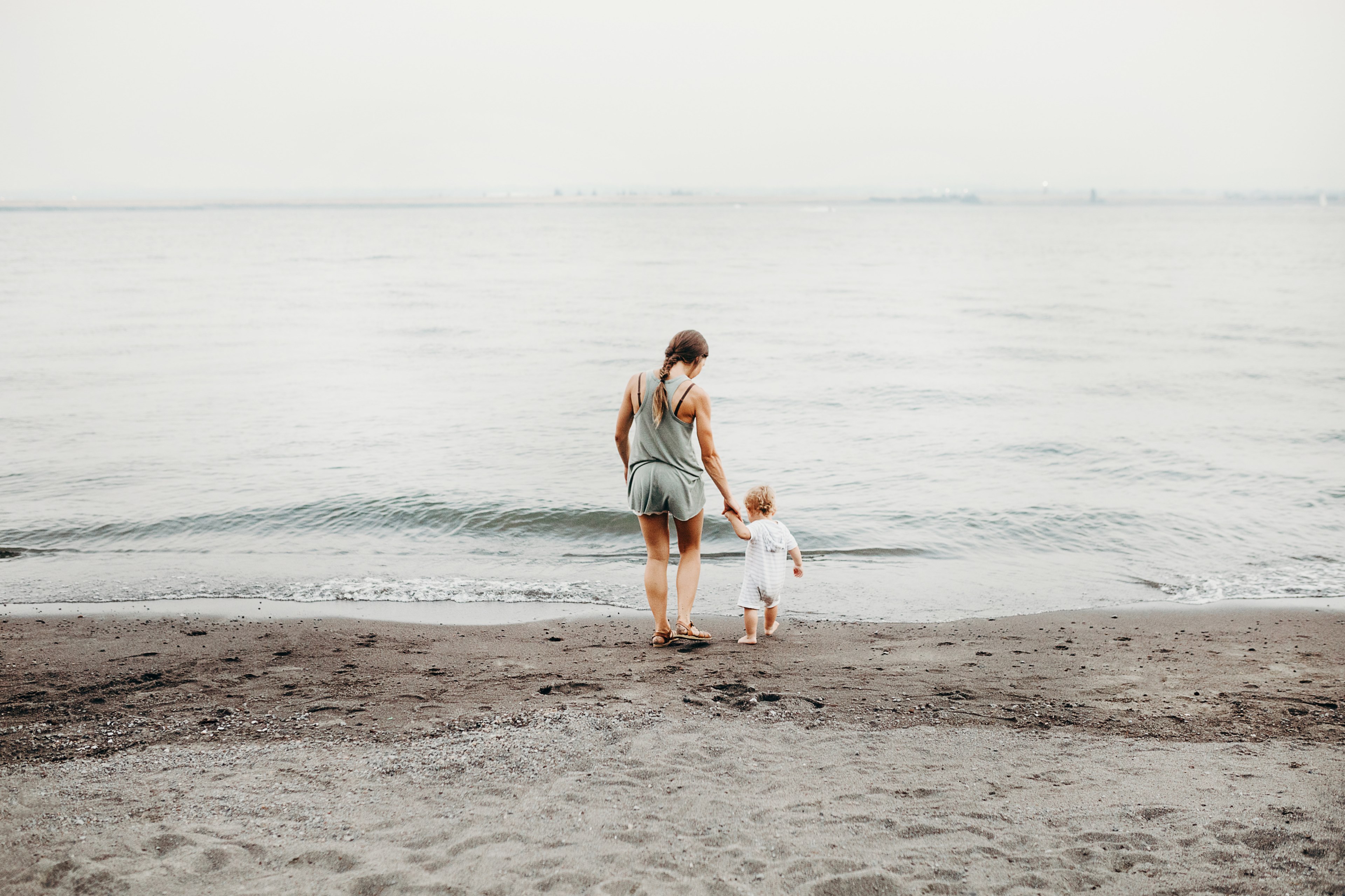 a mother and daughter walking down the beach near the water in wintler community park, motherhood 4k, HD Wallpaper