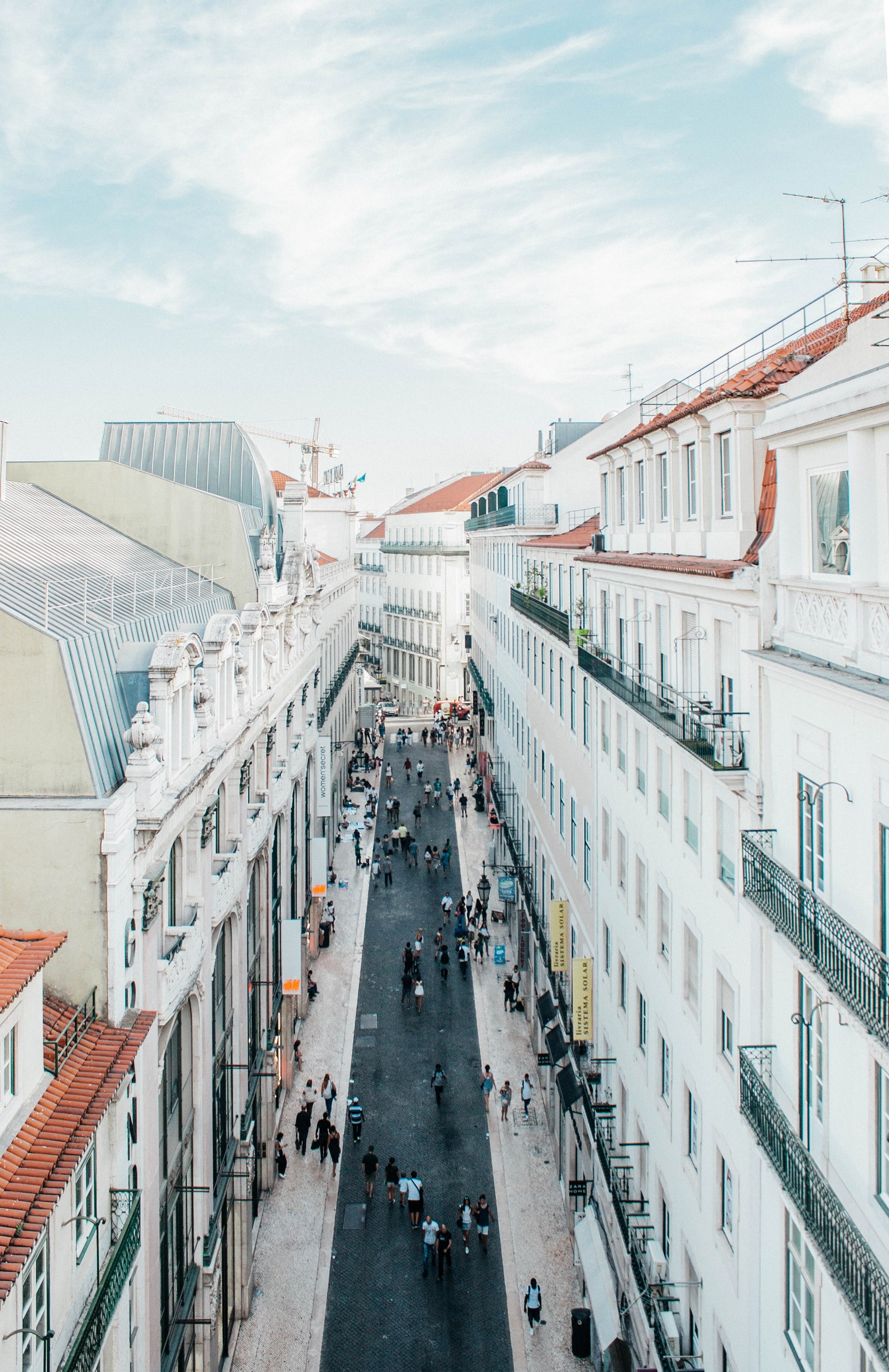 pedestrians in a narrow street lined with white tenement houses in lisbon, white buildings in lisbon 4k, Phone HD Wallpaper