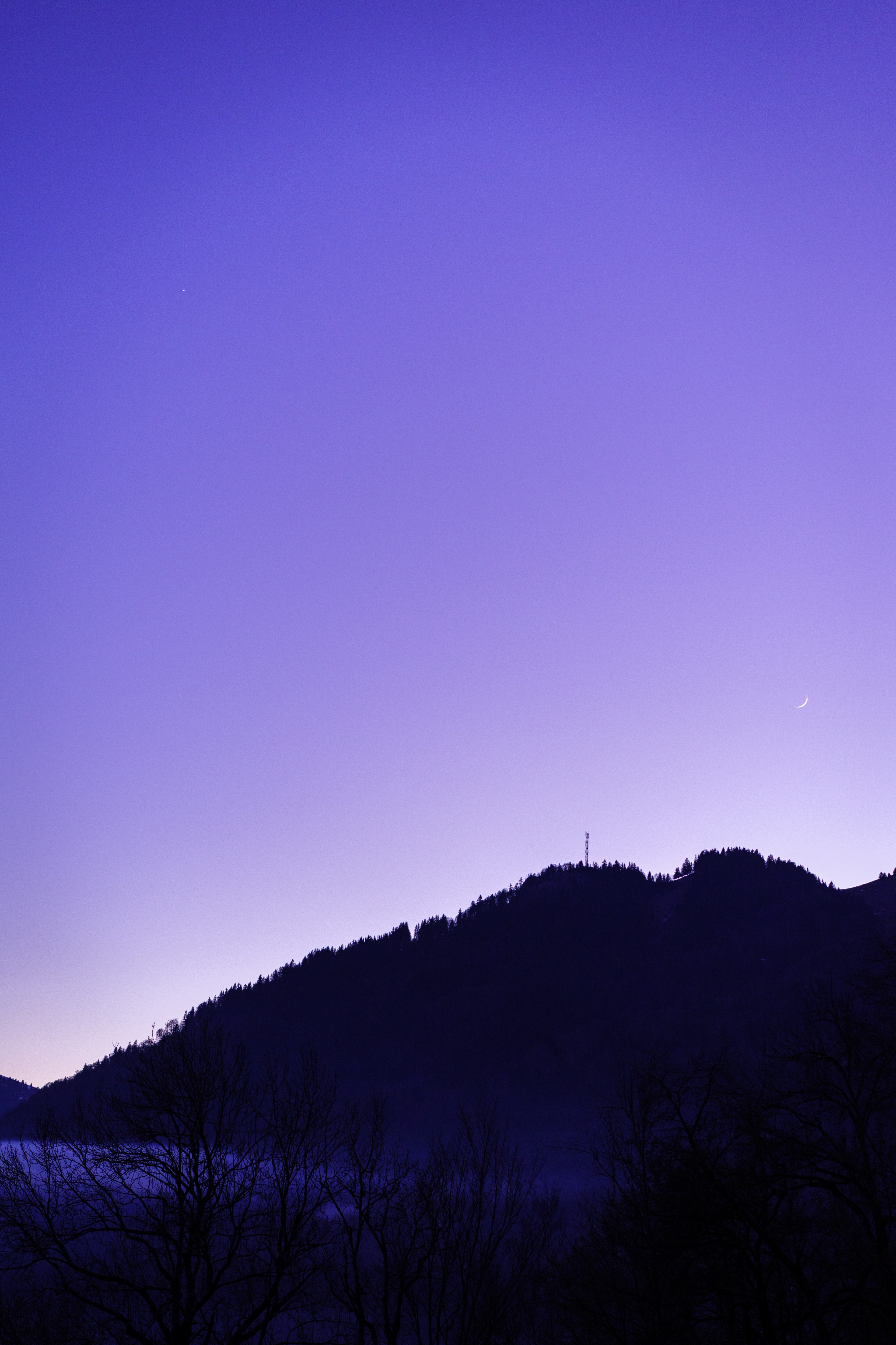 a crescent moon hangs low above the hills silhouetted against a purple sky, moon in the blue sky 4k, Phone HD Wallpaper