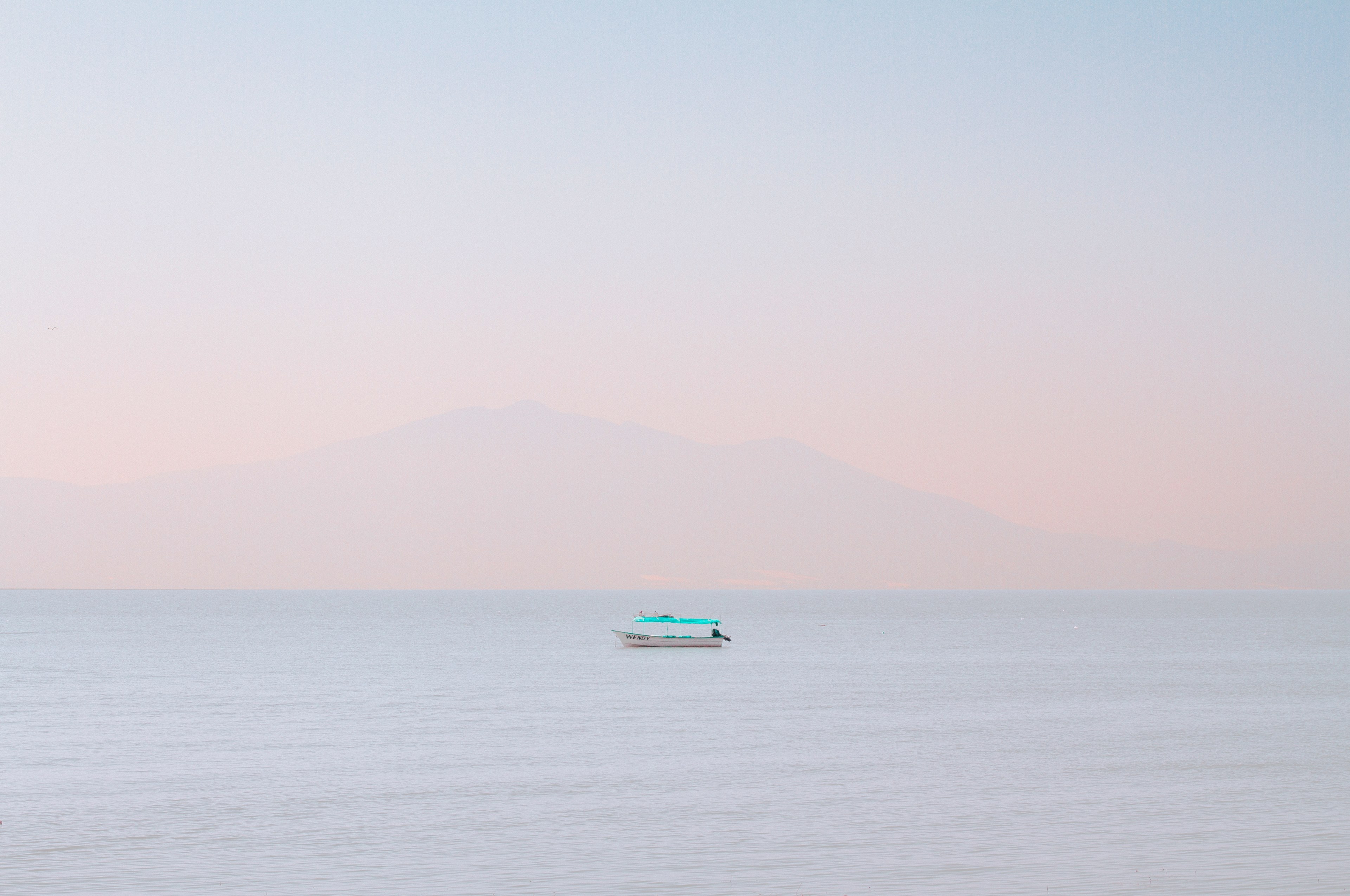 a single boat floating on the calm water during sunset or sunrise in chapala, pastel sky 4k, HD Wallpaper
