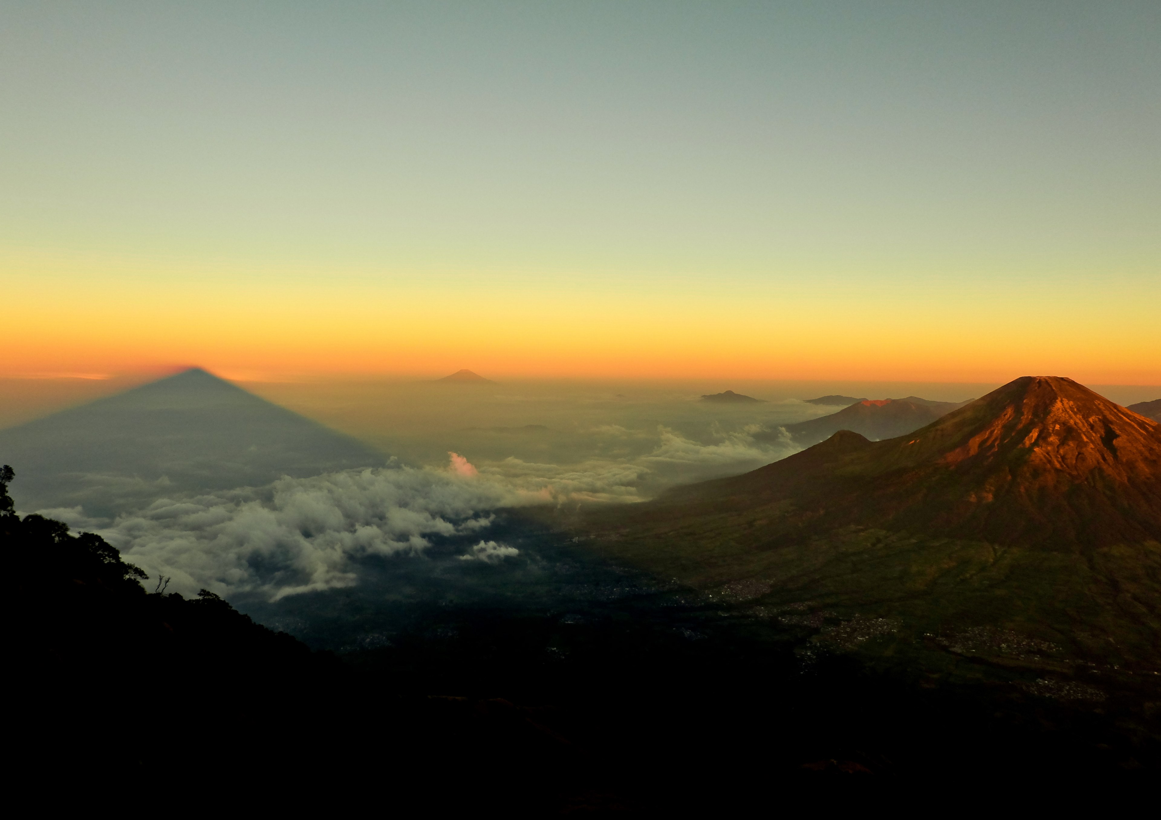 a volcano towering above a vast cloud covered plain during sunset, volcano at dusk 4k, HD Wallpaper