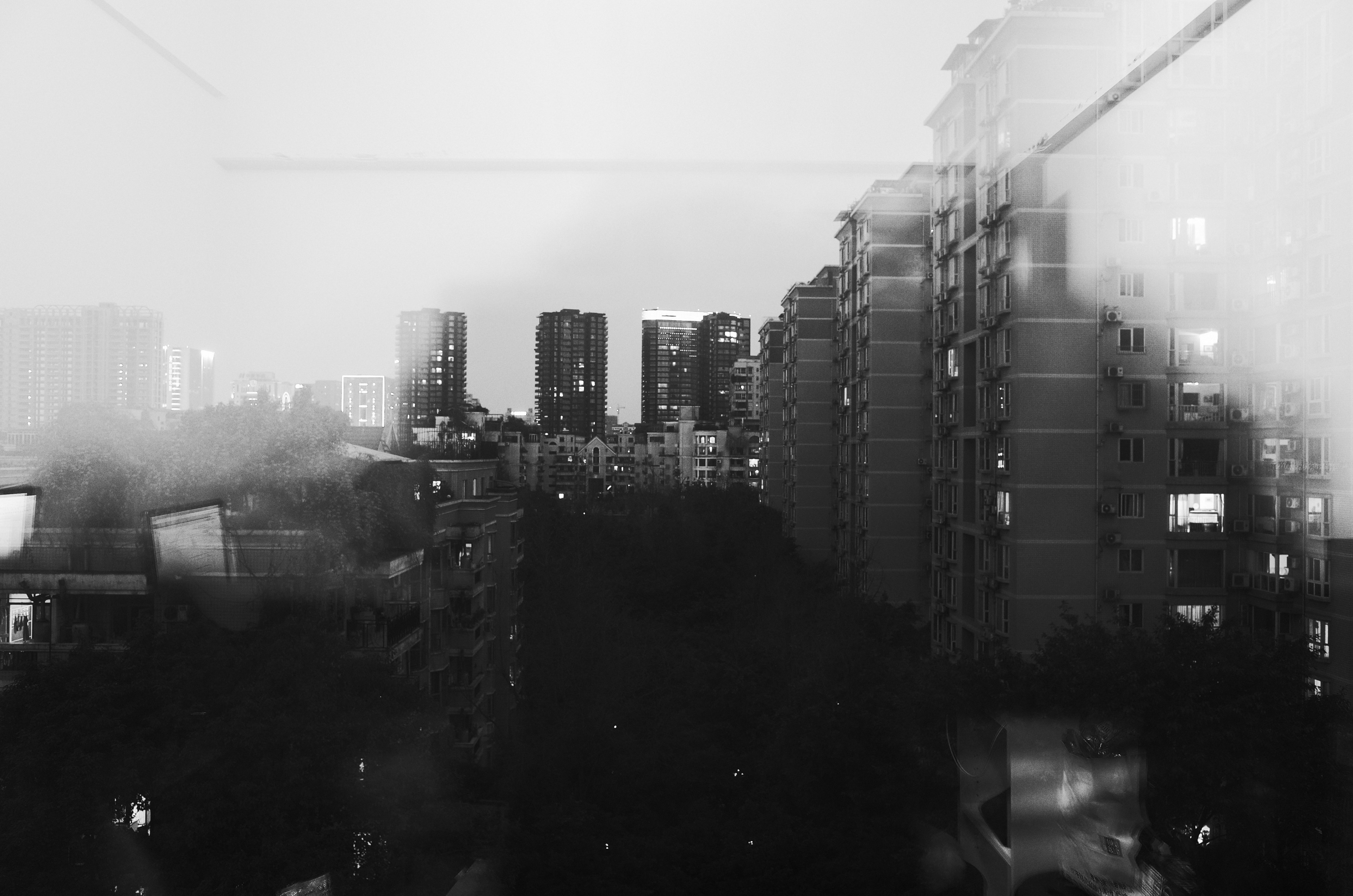 a fuzzy black and white shot of an apartment complex seen through a window, window shot of urban flats 4k, HD Wallpaper
