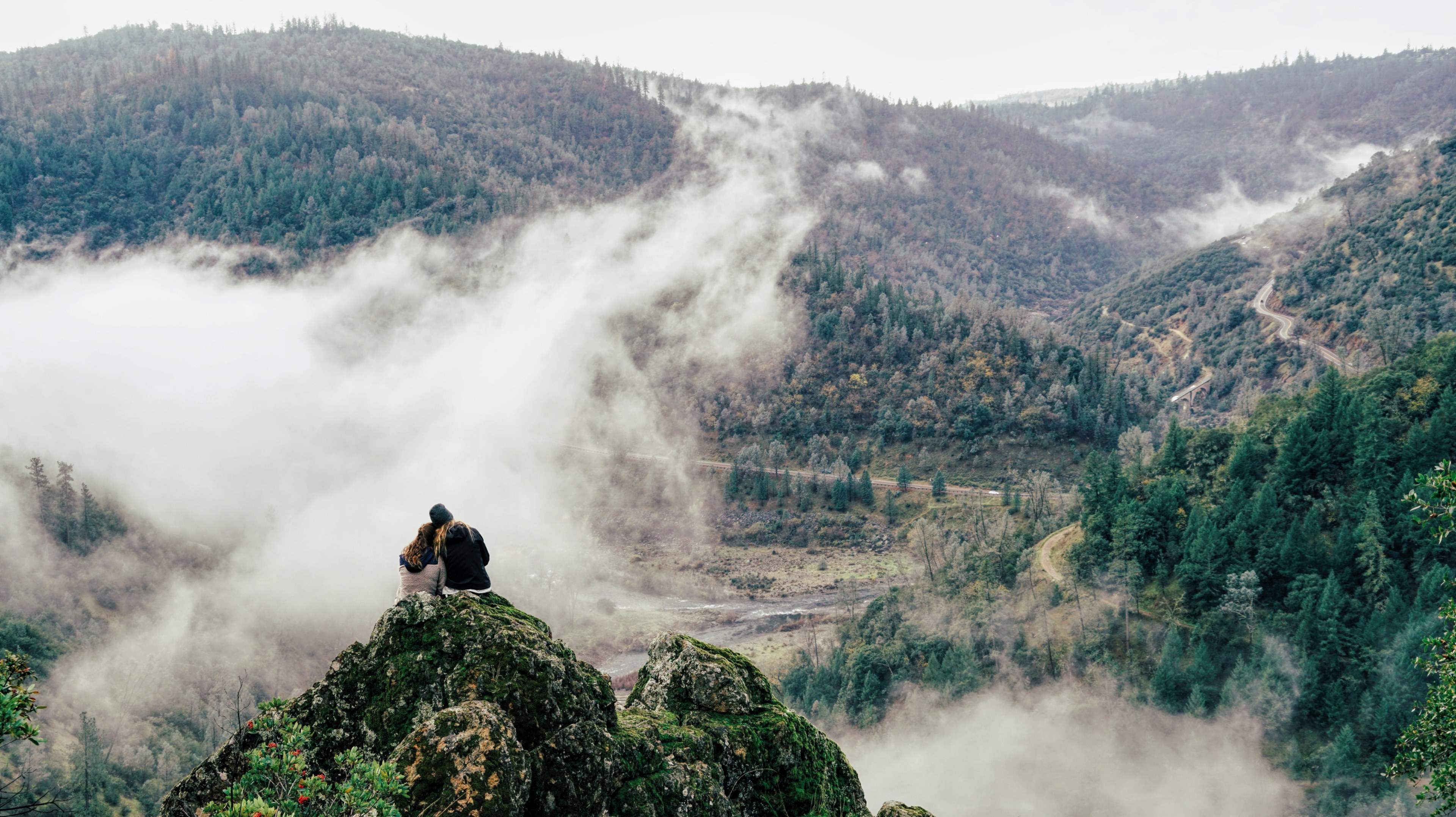 two people leaning against each other on a moss covered ledge in the mountains, the great beyond 4k, HD Wallpaper