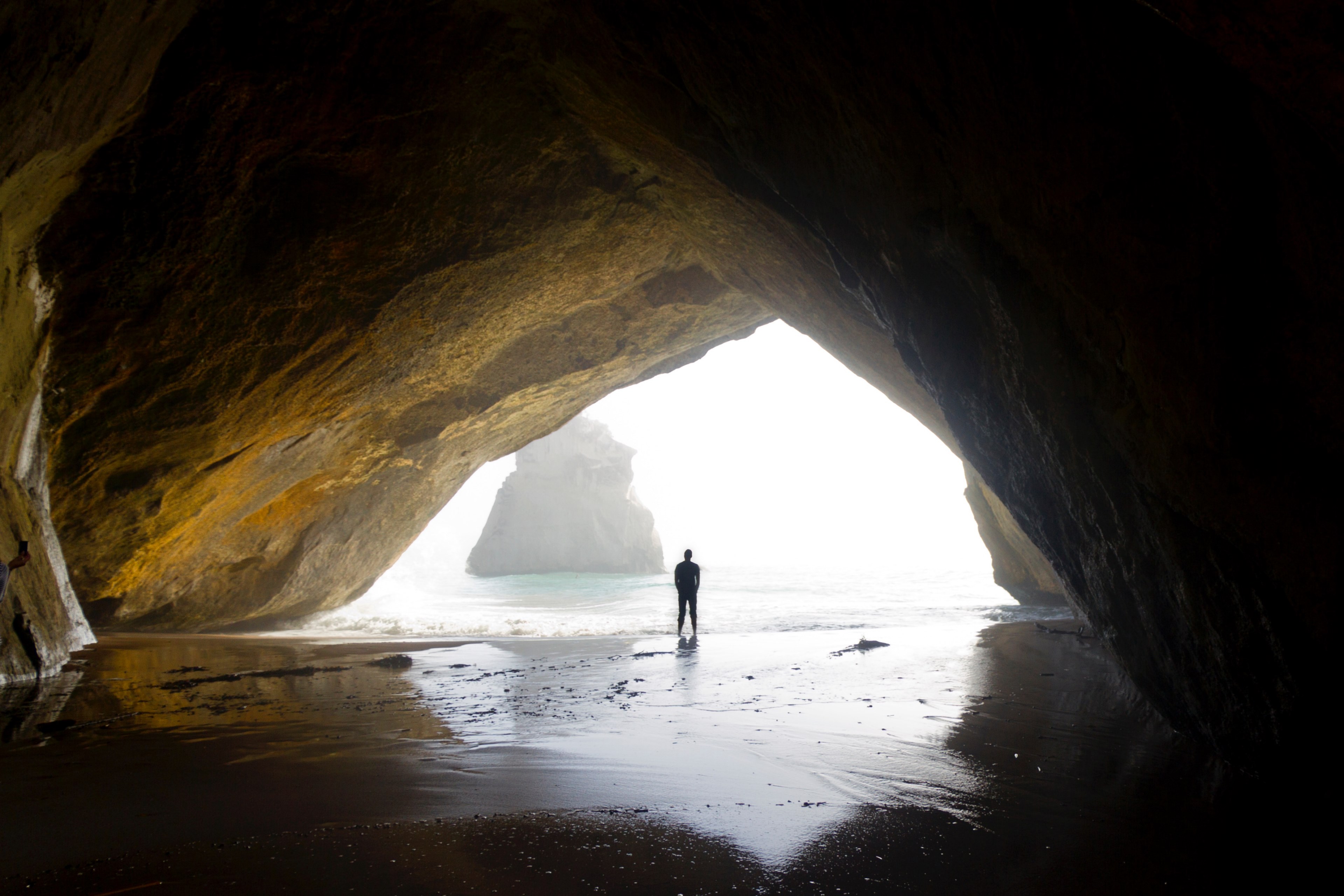 man standing at the beach cave entrance in te whanganui a hei marine reserve, man at the beach cave entrance 4k, HD Wallpaper
