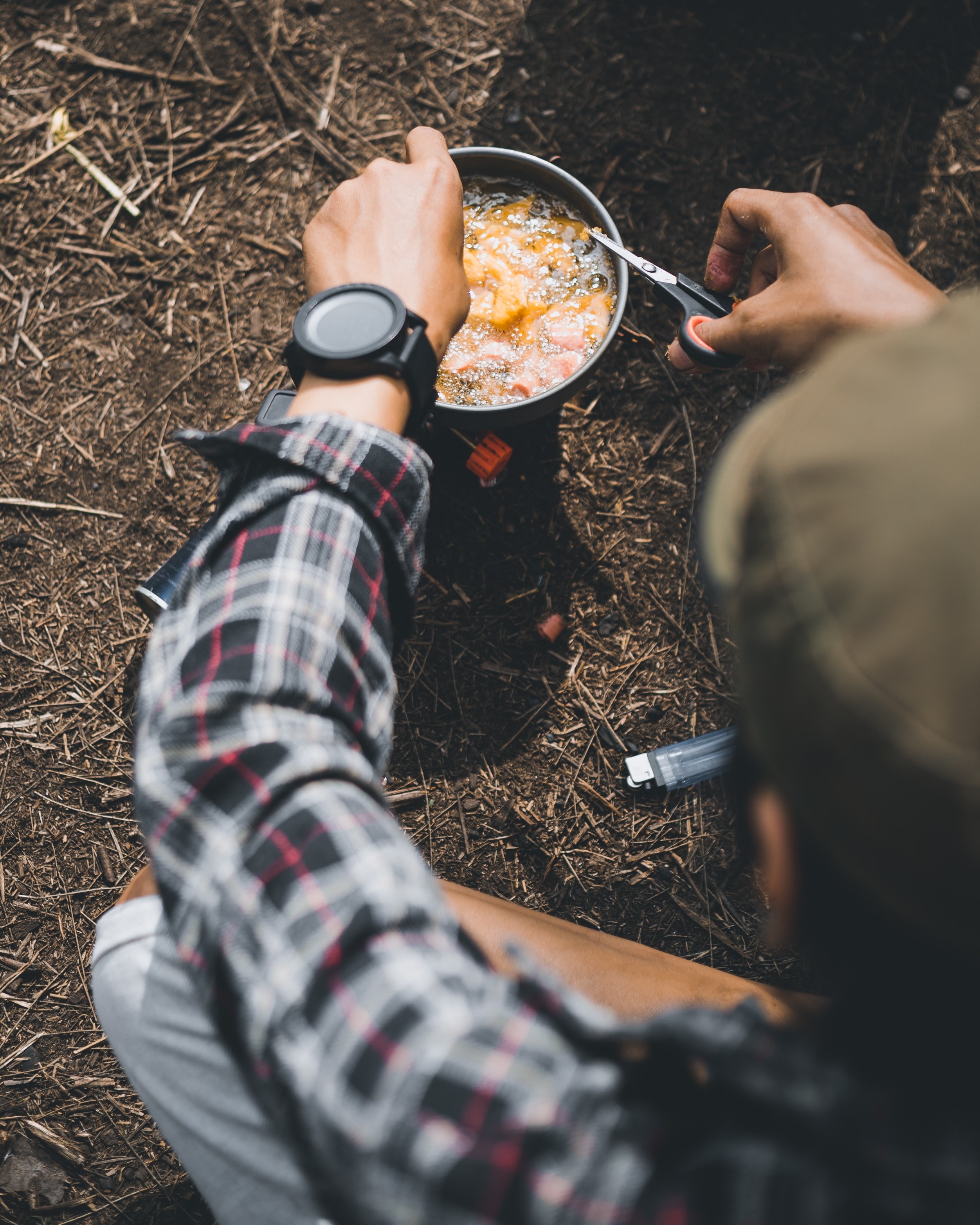a man in plaid shirt wearing a watch is cooking on a camping stove in pacet, _cooking on a portable stove 4k, Phone HD Wallpaper