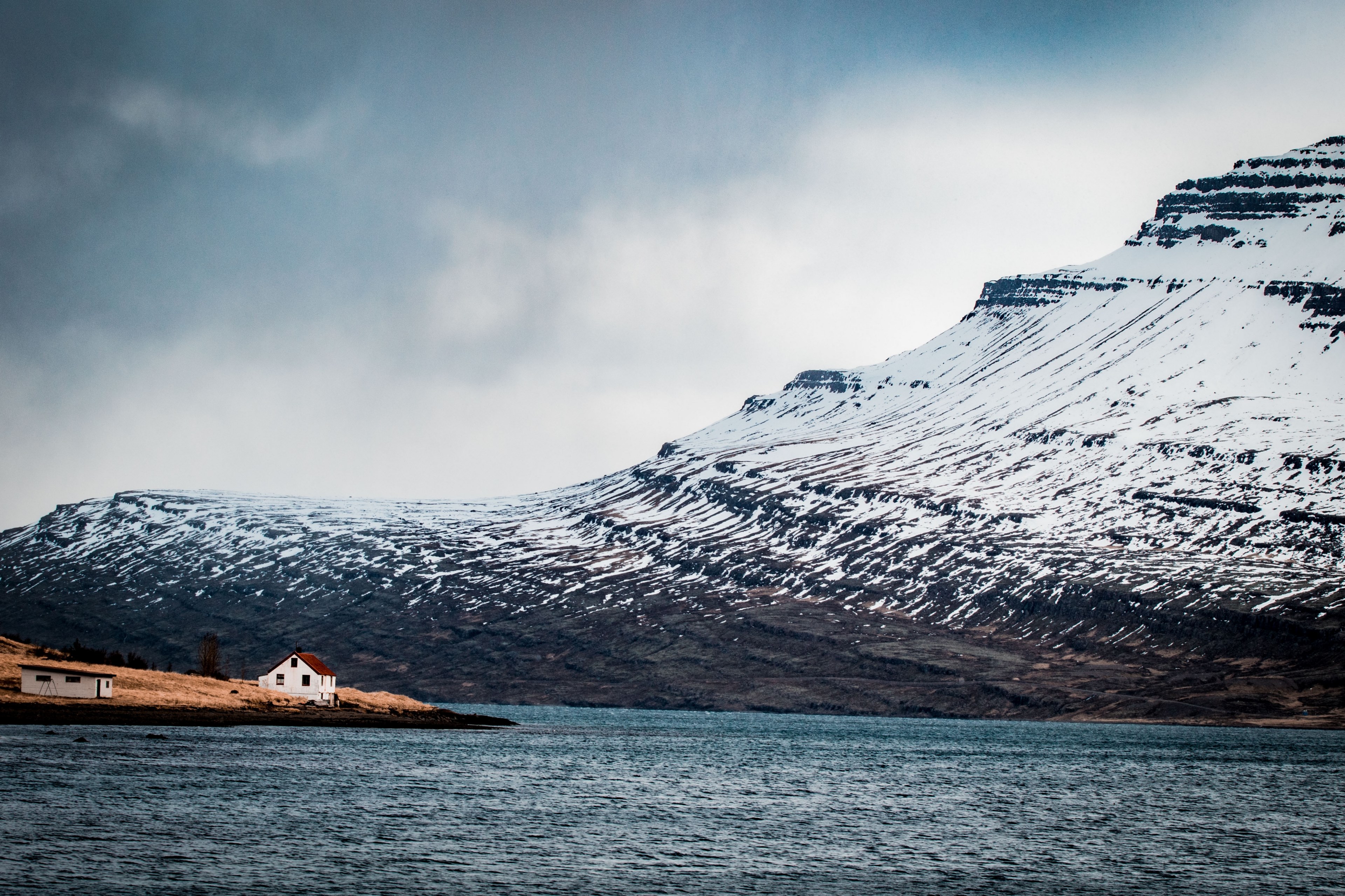a house and a shed on a shore of a lake with snowy mountain slope at the other shore, welcome to reyarfjrur 4k, HD Wallpaper
