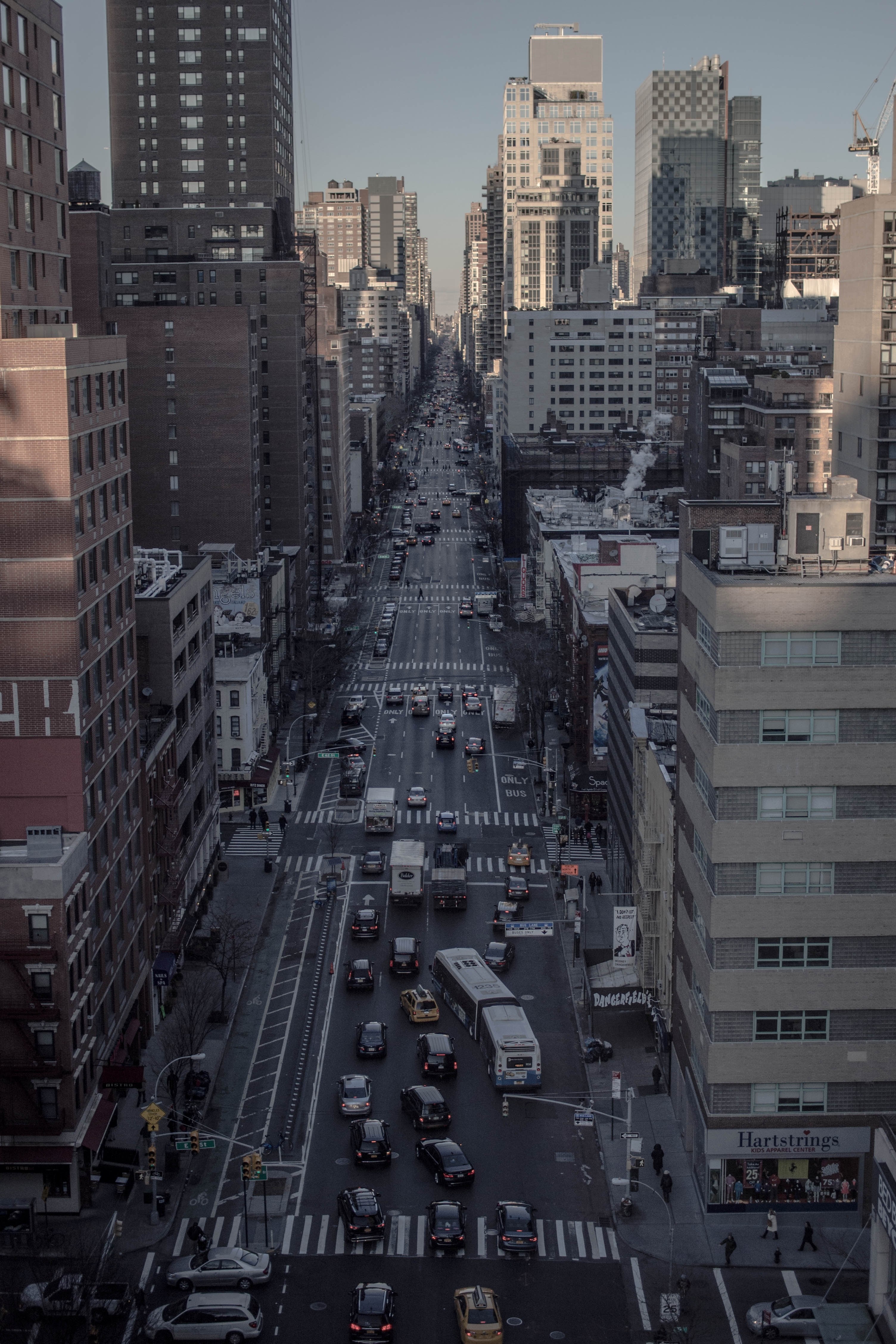 shadowy aerial view of a new york city street with cars taxis and buses, be there in a new york minute 4k, Phone HD Wallpaper