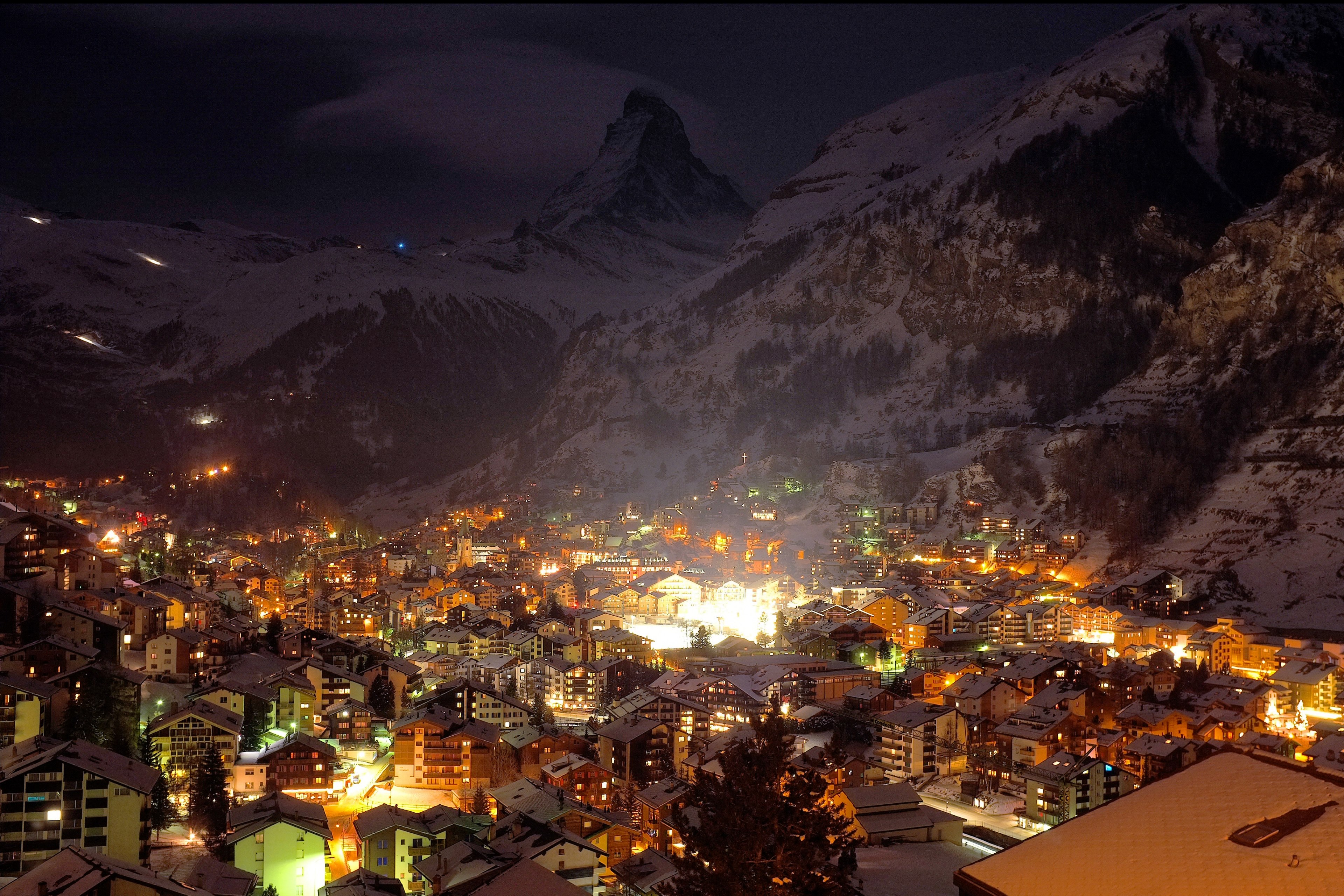 a village at night with all buildings lit up with a snow covered mountain in the background, mountain village at night 4k, HD Wallpaper