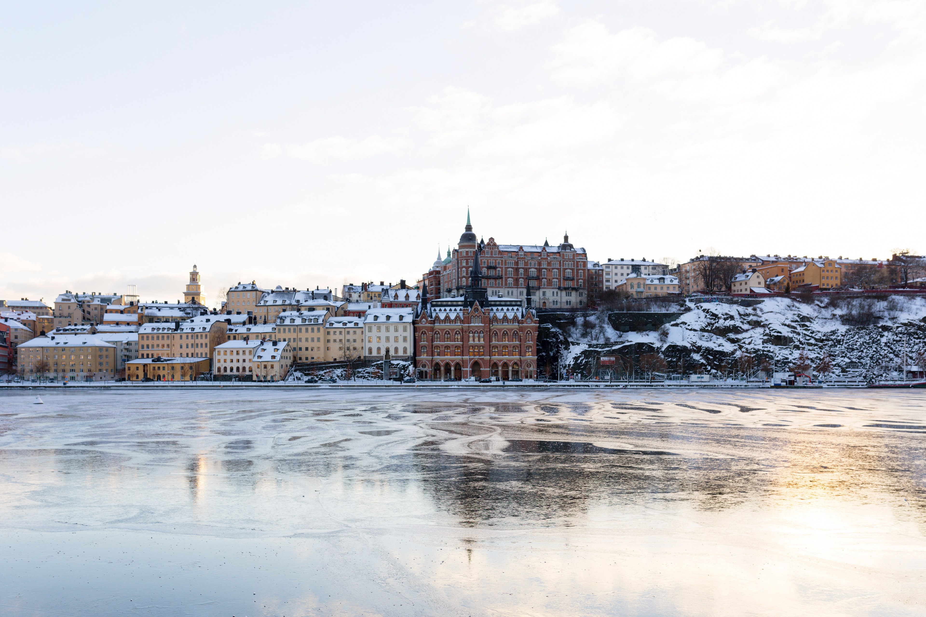 a swedish city with tan and brown buildings by the shore of a frozen lake, stockholm 4k, HD Wallpaper