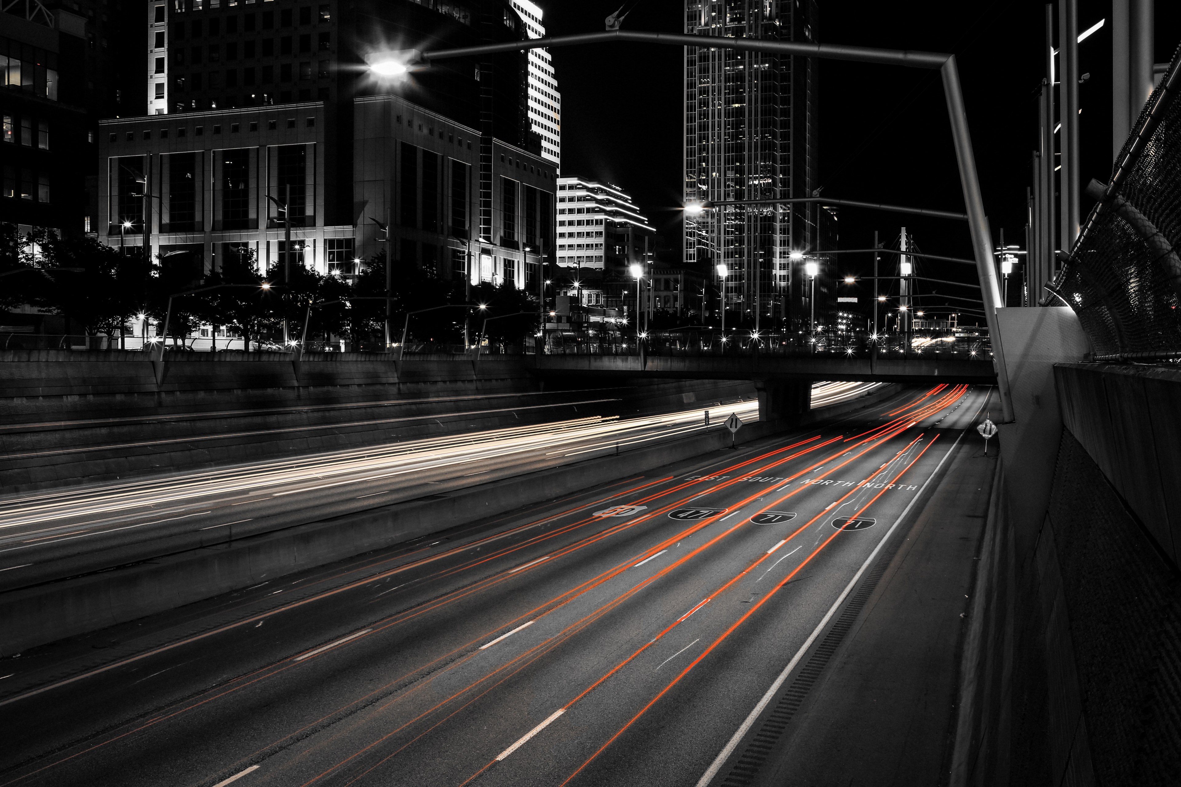a desaturated shot of a cincinnati road with red light trails from the tail lights of passing cars, red tail light lines 4k, HD Wallpaper
