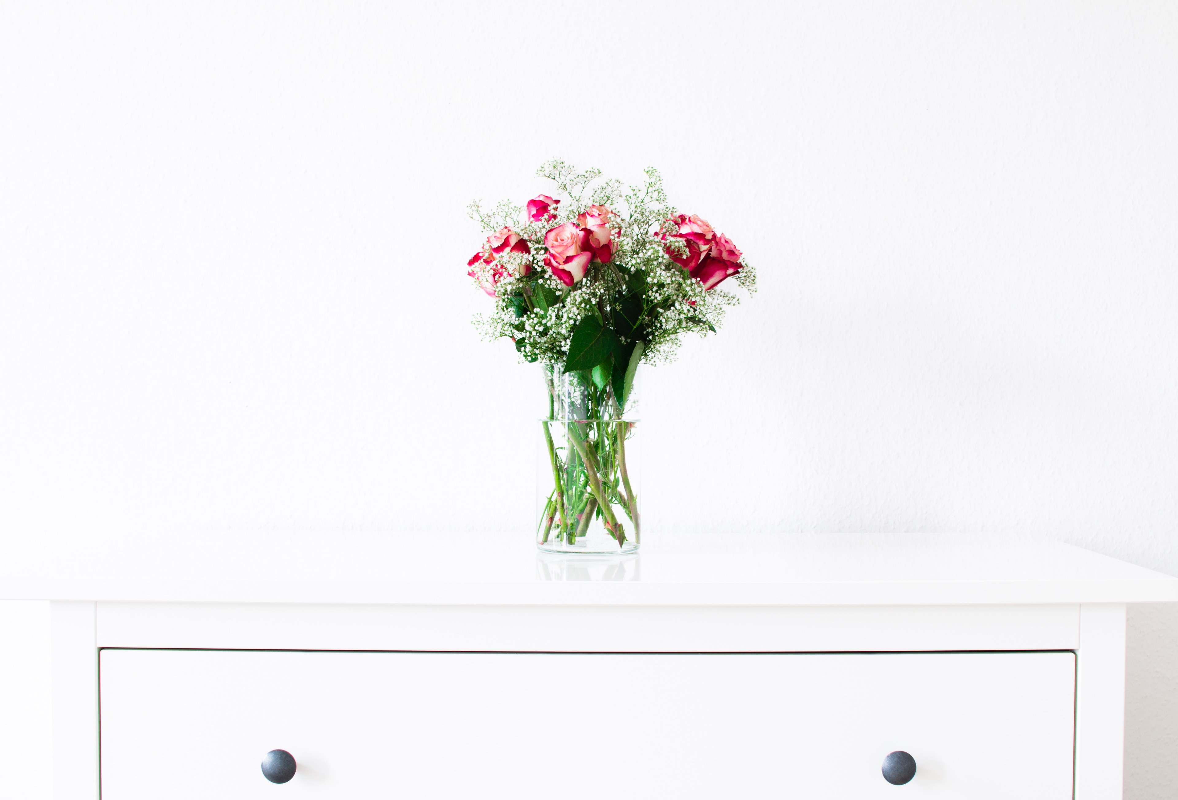 a bouquet of roses in a glass vase on a white cabinet, rose bouquet in a sea of white 4k, HD Wallpaper