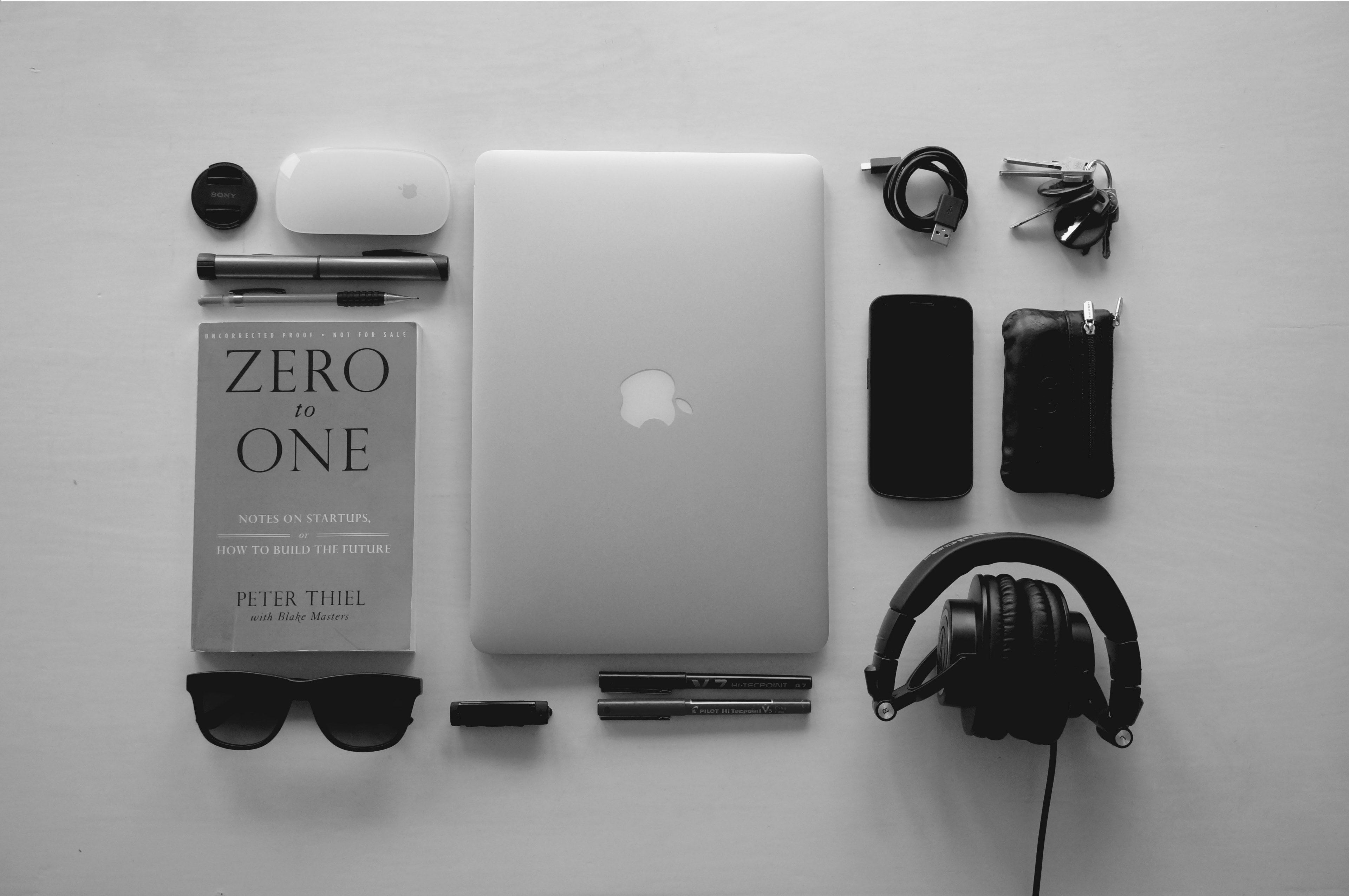a neatly arranged collection of technology and gadgets including a laptop and peter thiels book zero to one, work tools flat lay 4k, HD Wallpaper