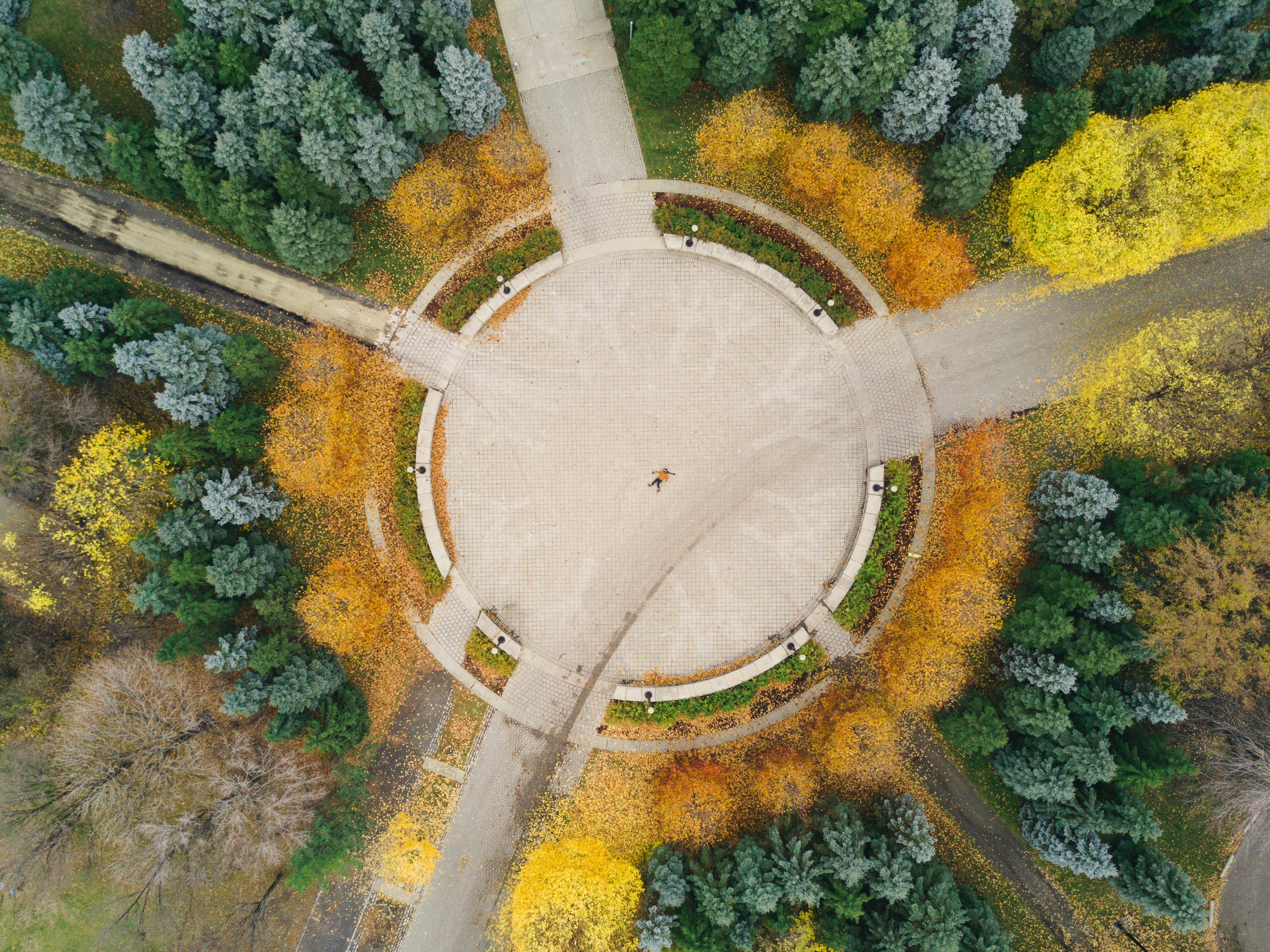 a drone shot of a person lying in the middle of a square in a park in the autumn, new drone who dis 4k, HD Wallpaper