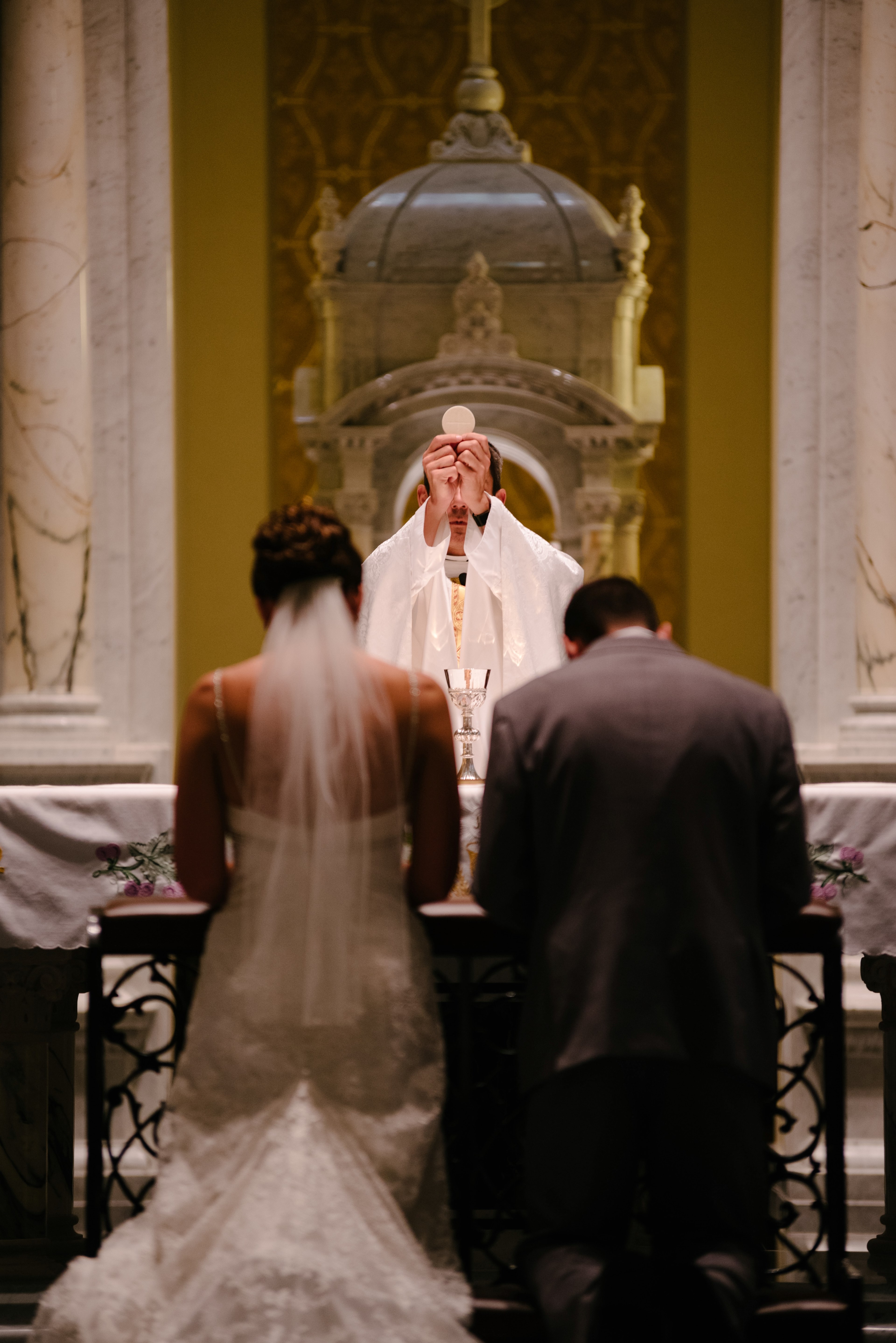 a priest holds up a communion wafer to a couple at the altar at a wedding, bless the bride and groom 4k, Phone HD Wallpaper