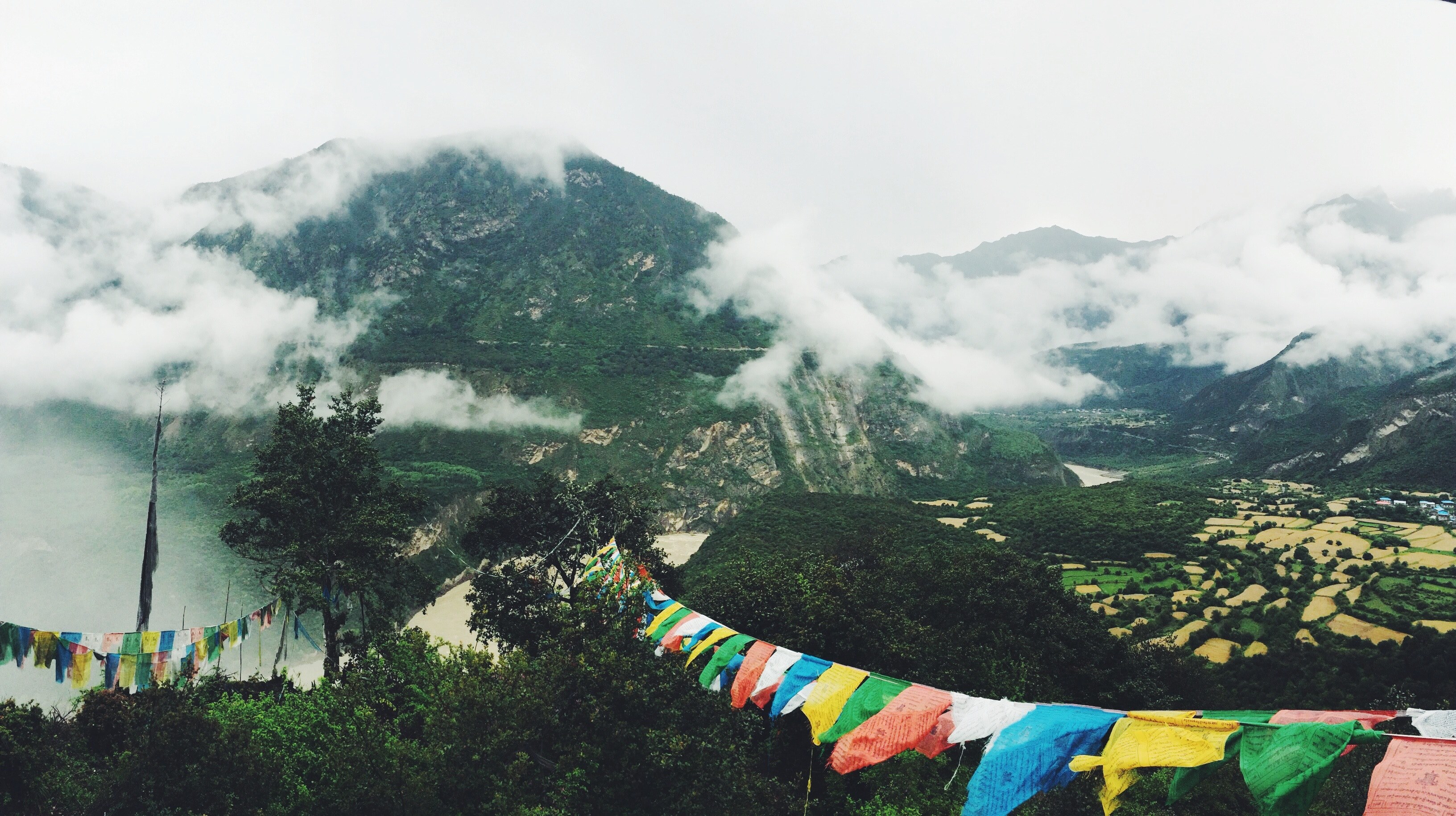 colorful bunting hanging between treetops with view on a cloud shrouded mountain, bunting in the mountains 4k, HD Wallpaper