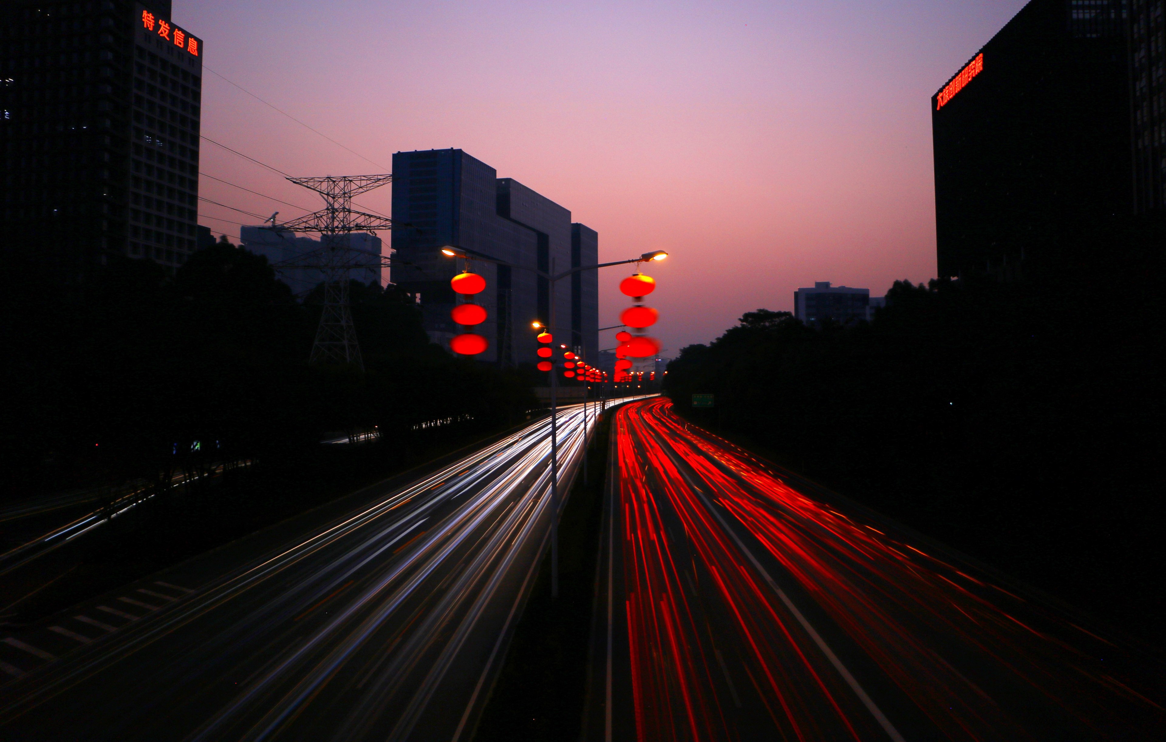 a dark dimly lit street with vivid traffic light trails taken at the beginning of night, traffic flow of commuting after chinese new year 4k, HD Wallpaper