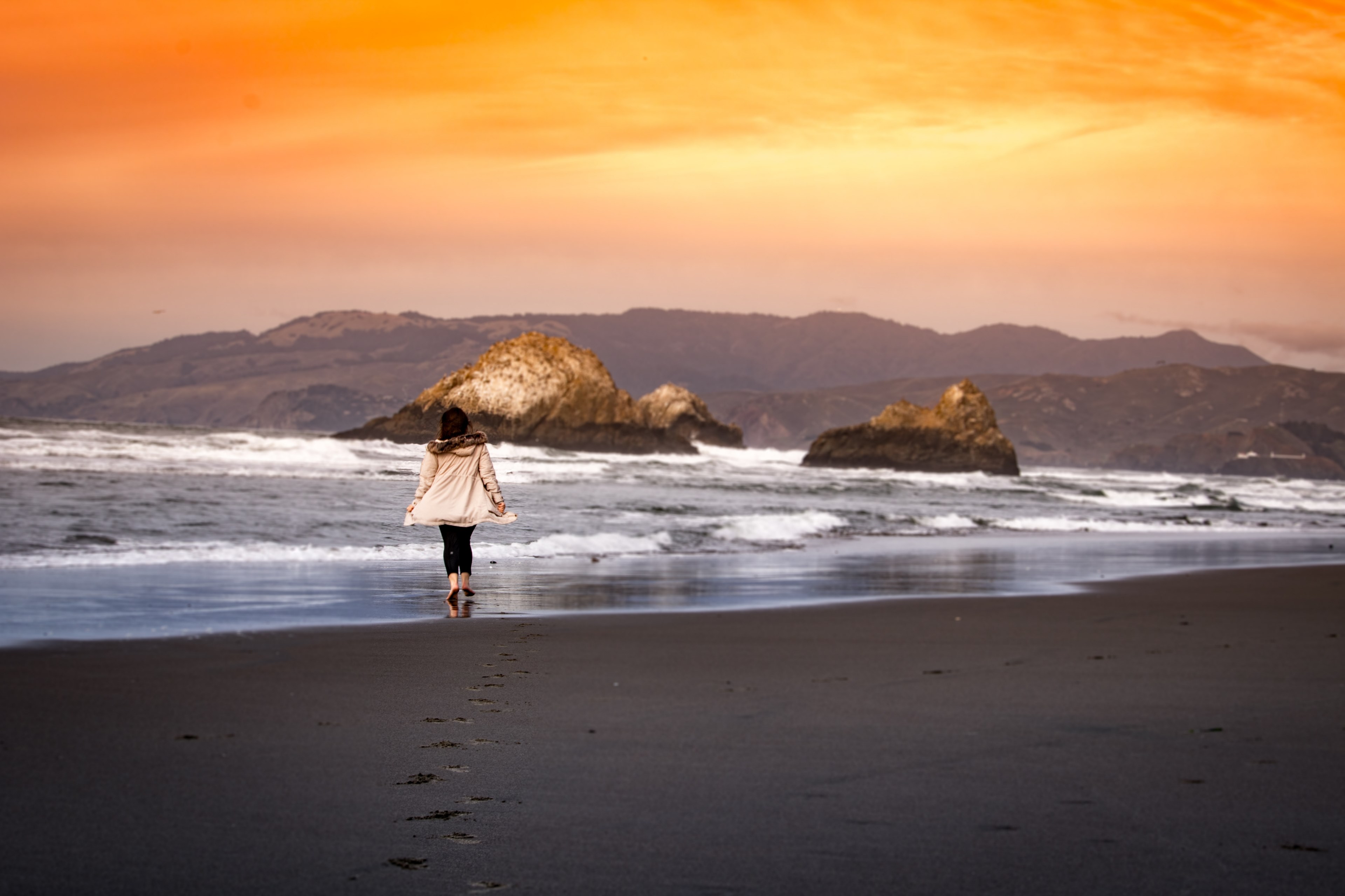 a woman walks across an empty beach as ocean waves crash on to the rocks and the sun sets in the sky, seal rocks 4k, HD Wallpaper