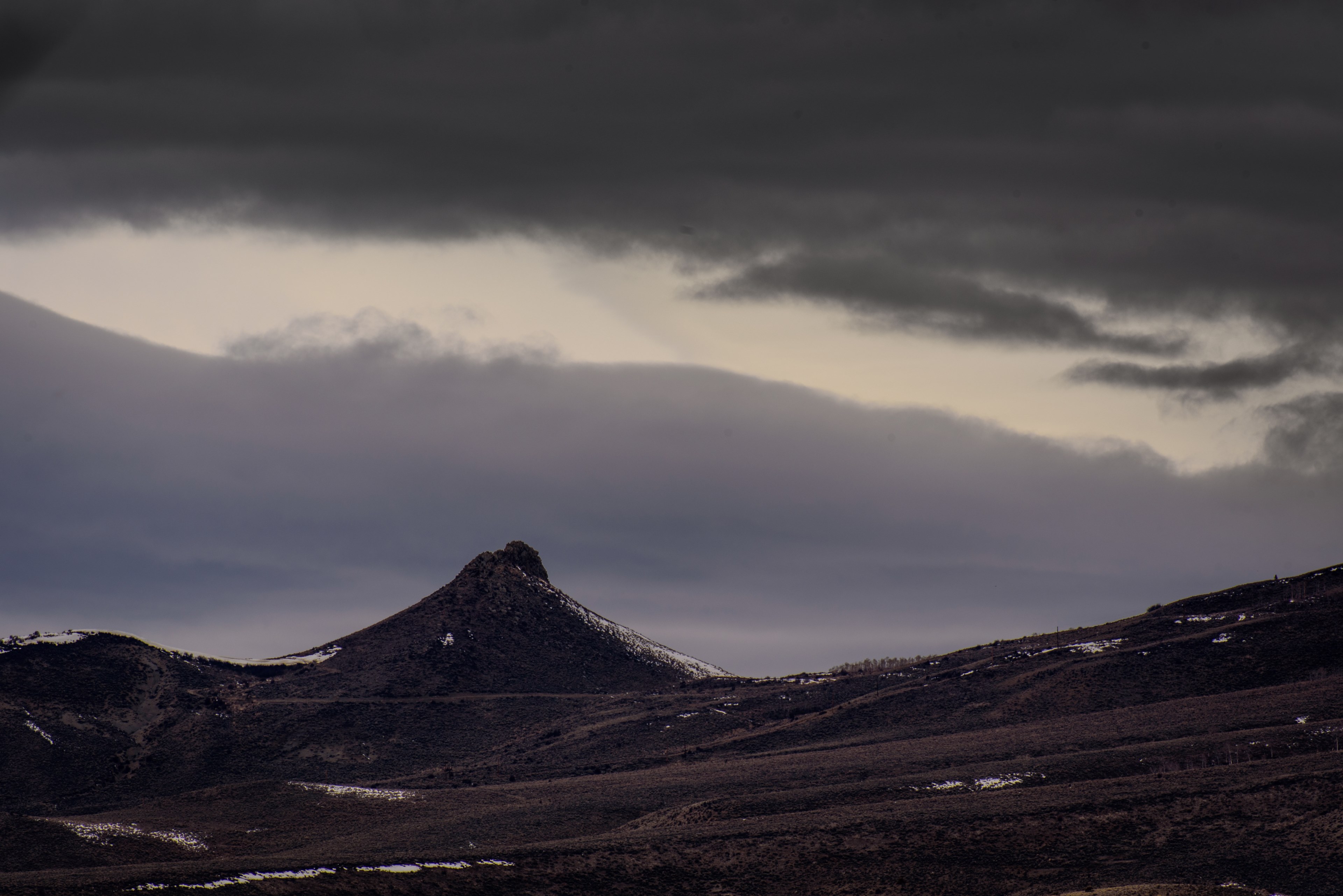 a jagged mountain peak crowns the horizon under thick clouds, lone mountain under clouds 4k, HD Wallpaper