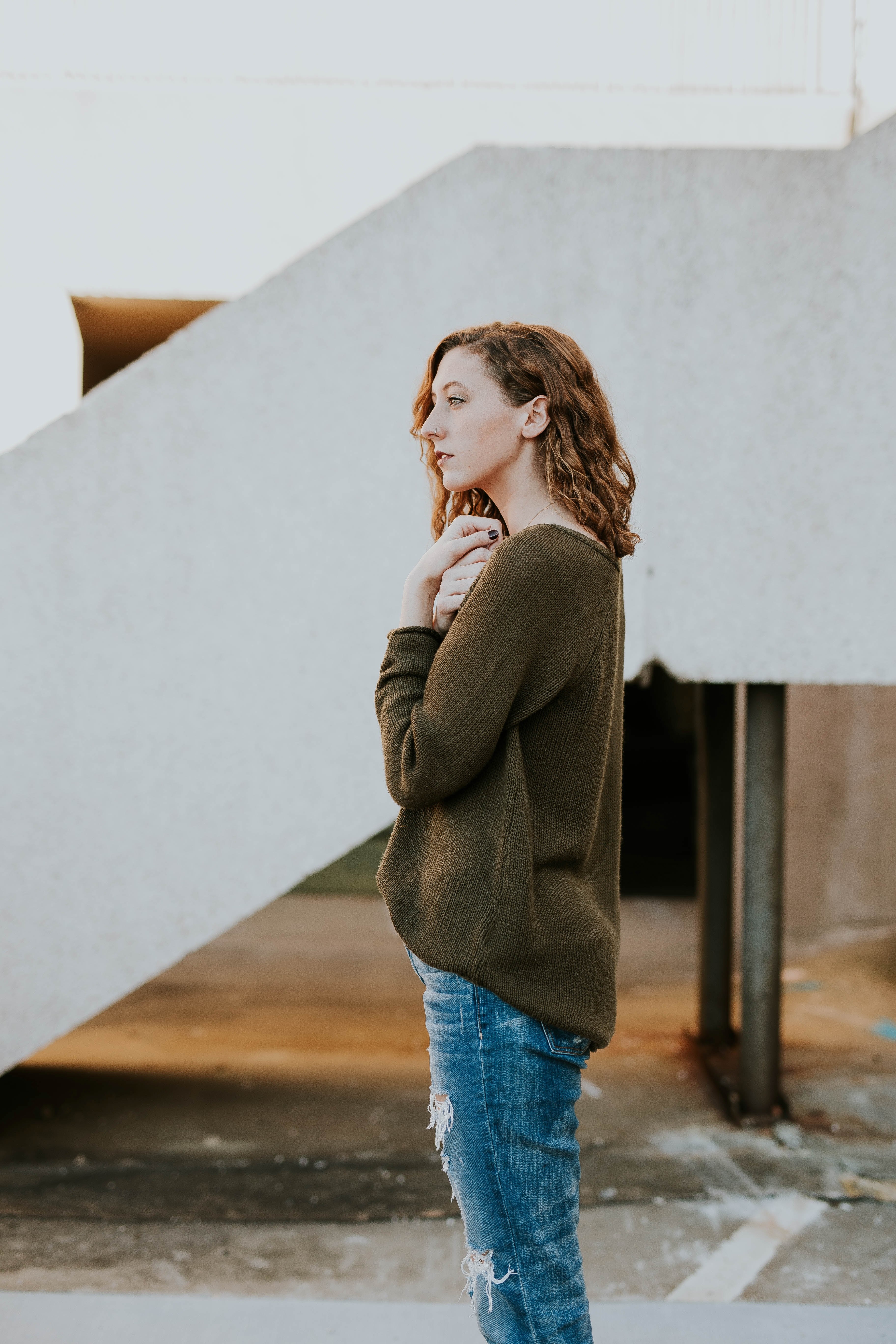 woman with arms tucked into her chest alone by an industrial site, lost in thought 4k, Phone HD Wallpaper