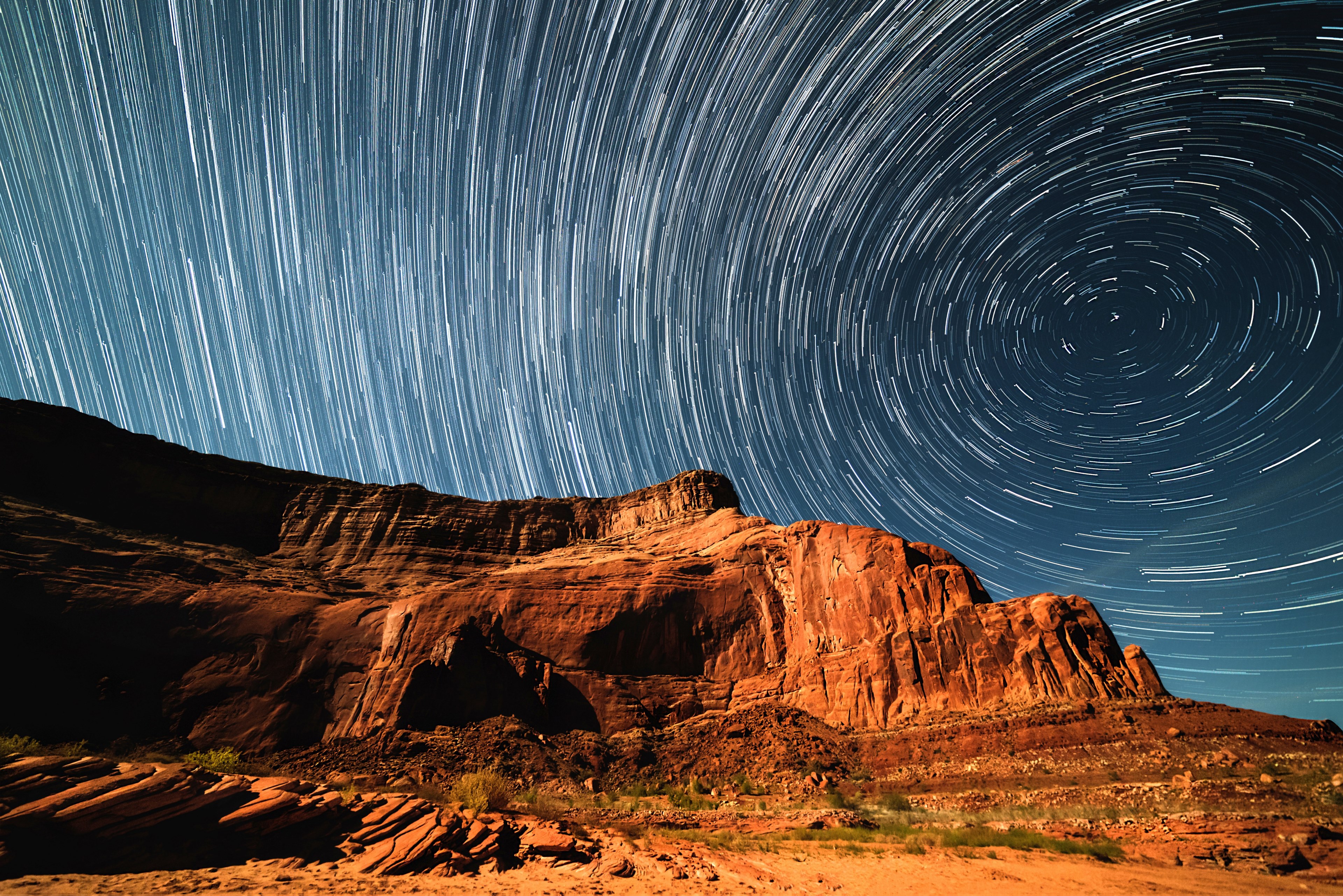 a blurry background image that perfectly captures swirling stars in a night sky over lake powell, cliff star trails 4k, HD Wallpaper