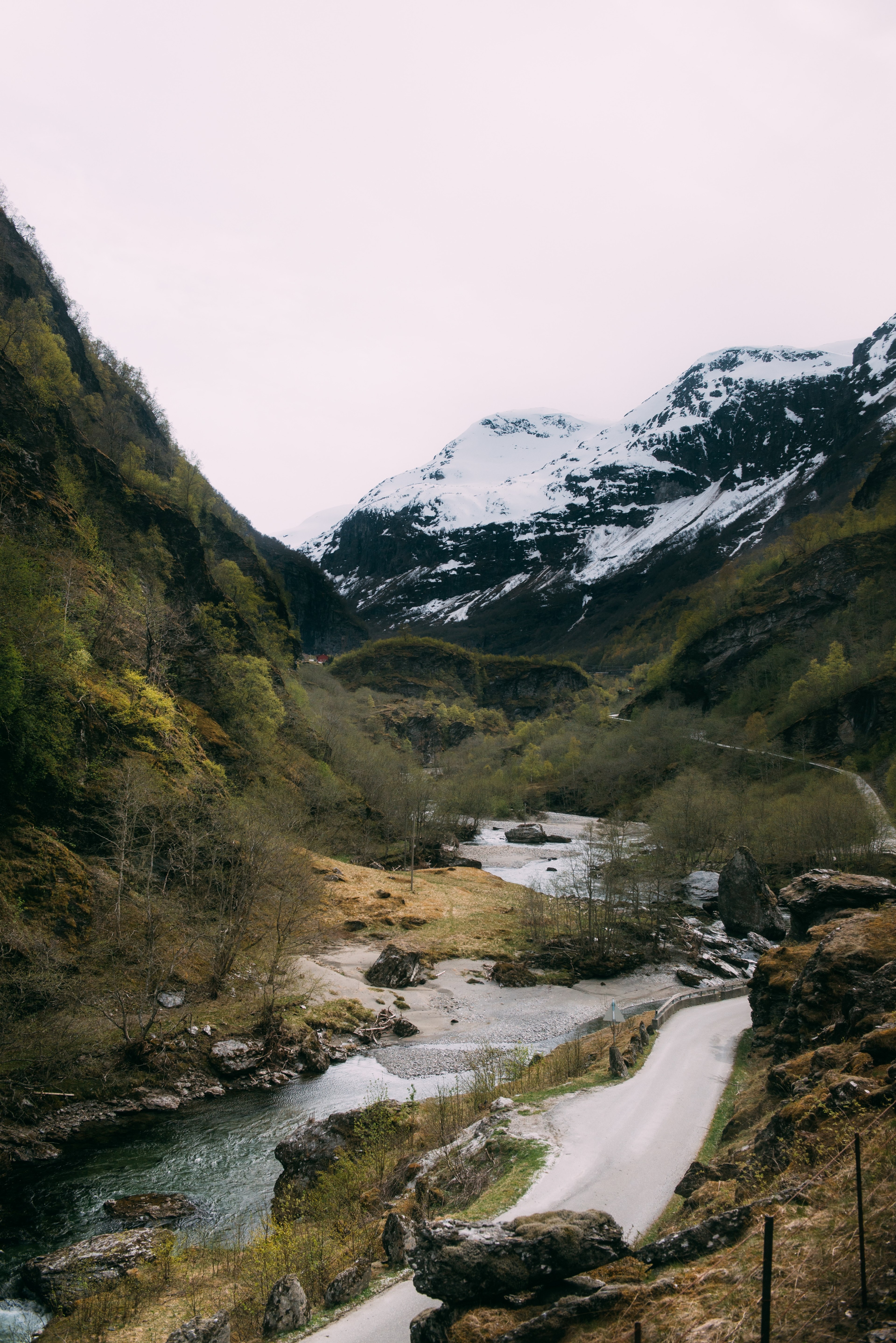 a fast flowing stream near a narrow asphalt road in the mountains, around flam 4k, Phone HD Wallpaper