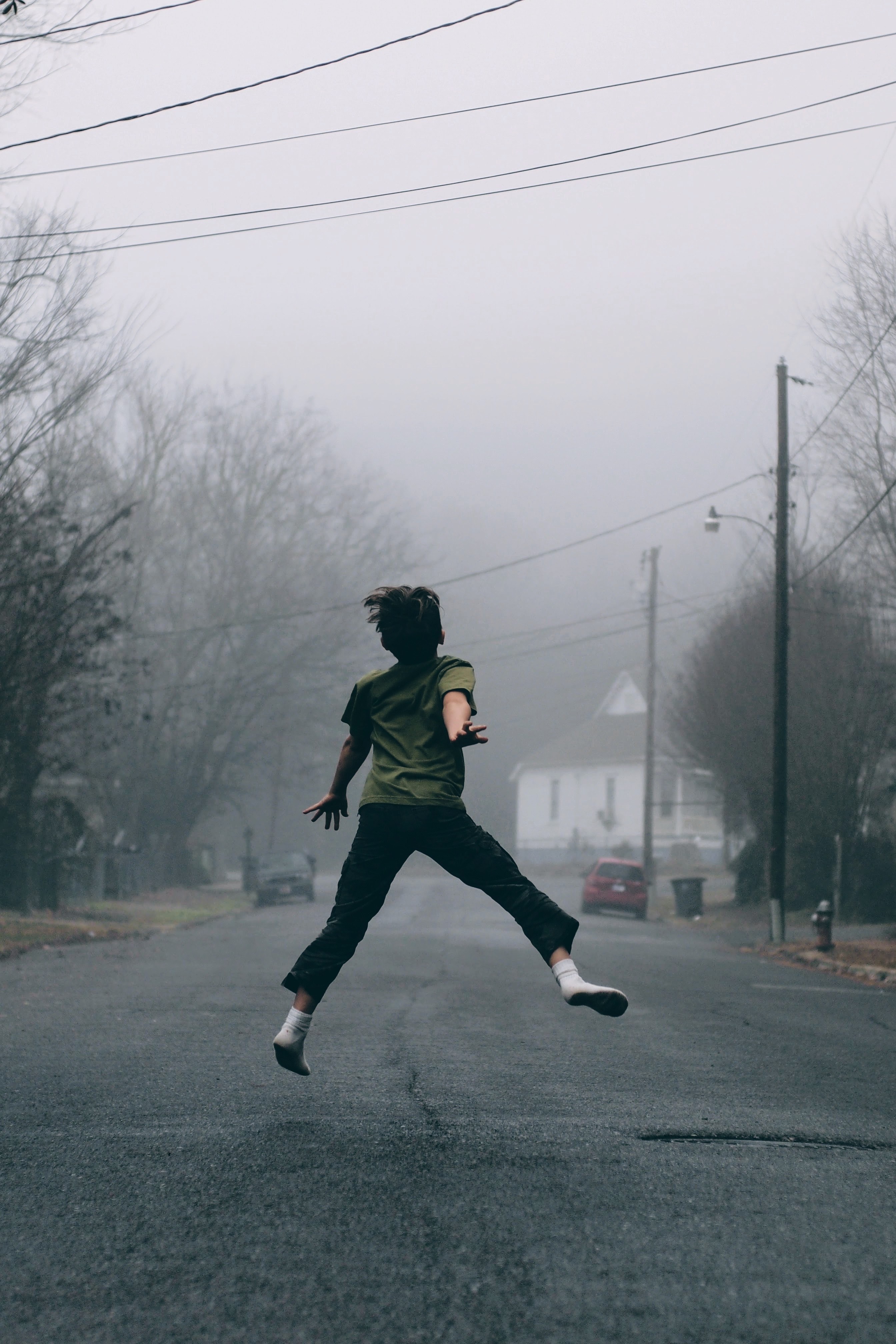 kid jumps in the middle of the road on a foggy day, socks in the street 4k, Phone HD Wallpaper