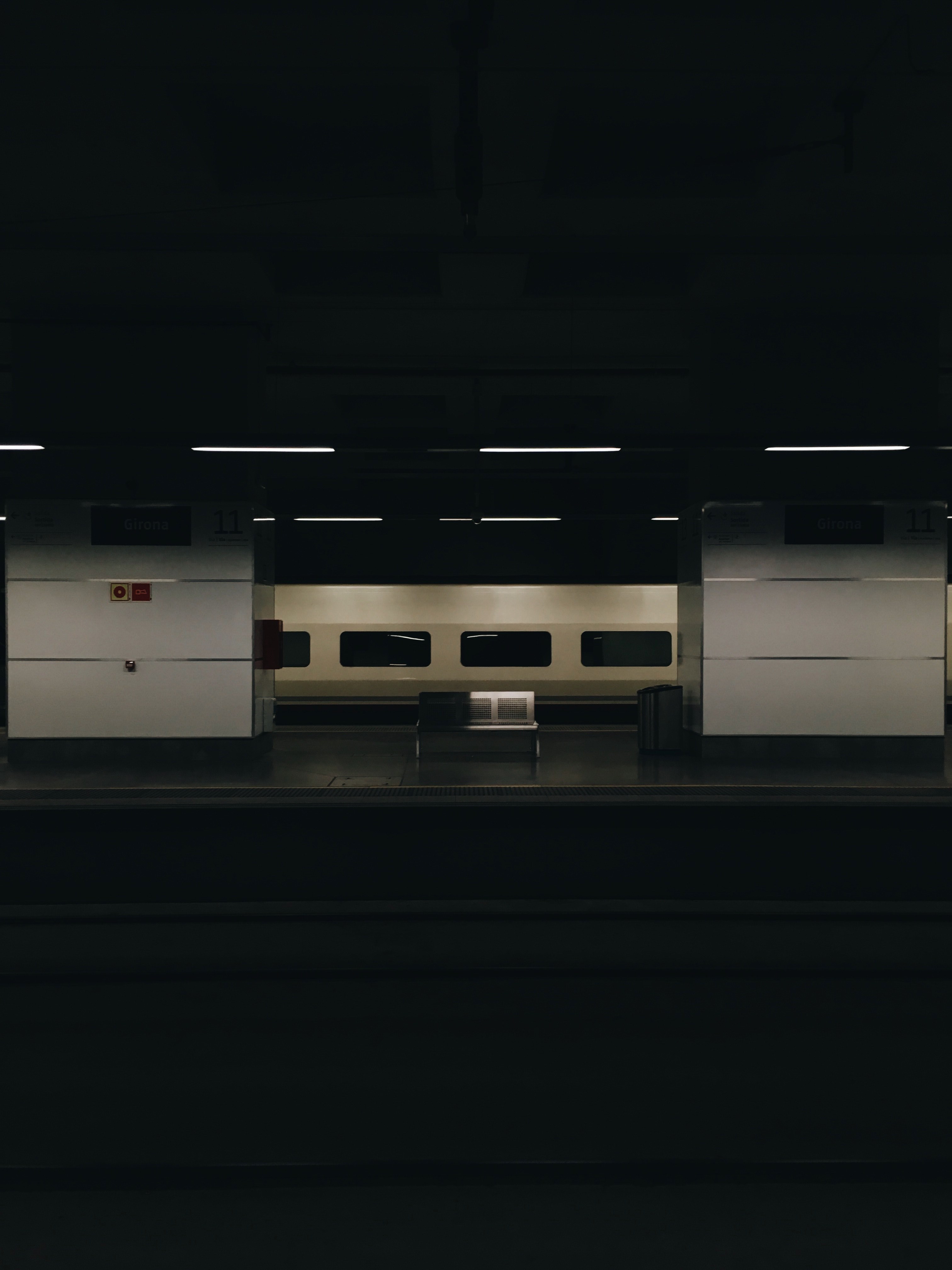 a dim shot of a metal bench on the other side of a railway platform, empty bench at a dark railway station 4k, Phone HD Wallpaper