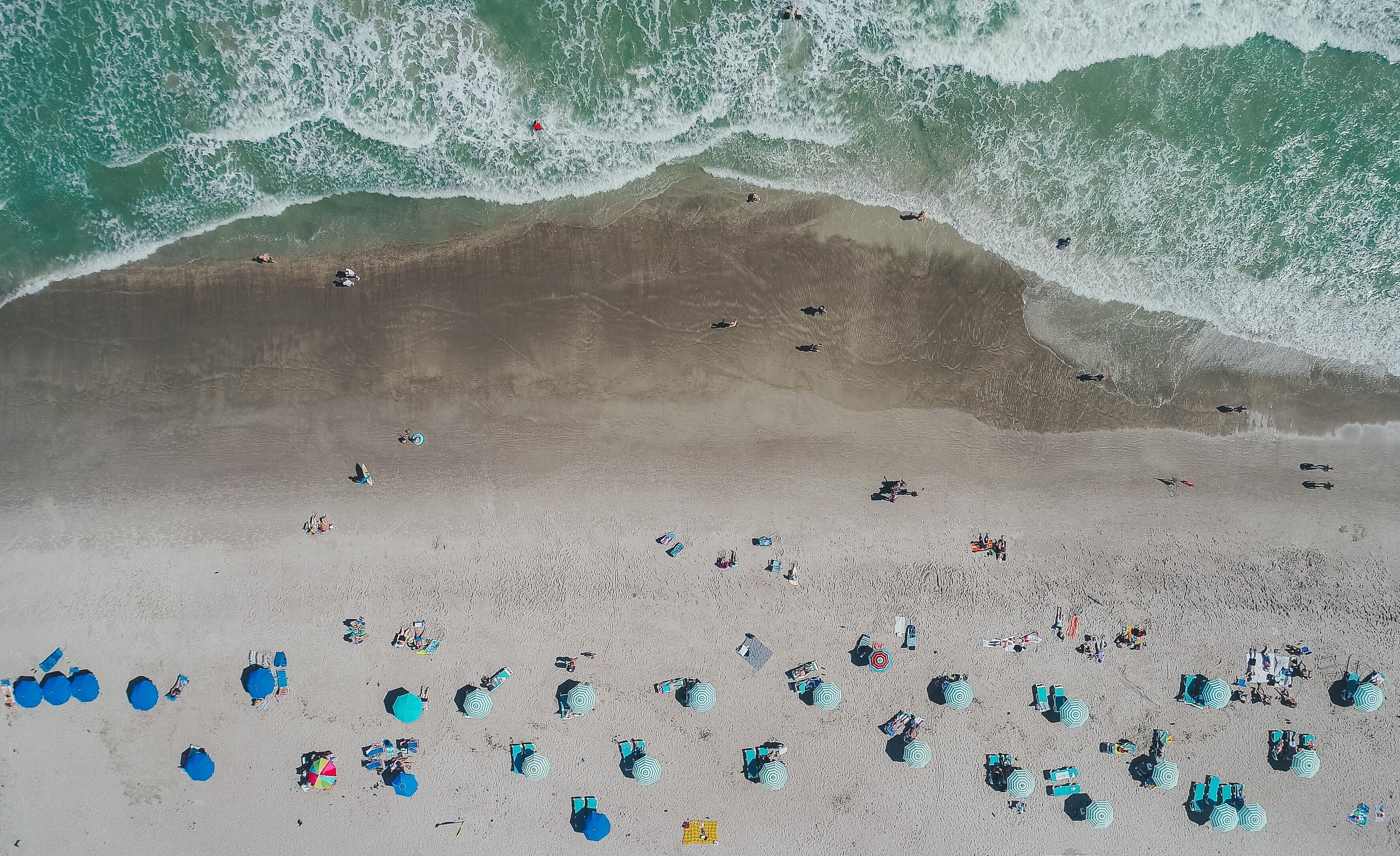 an aerial shot of vacationers on a sandy beach with blue umbrellas and deck chairs, clarity from above 4k, HD Wallpaper