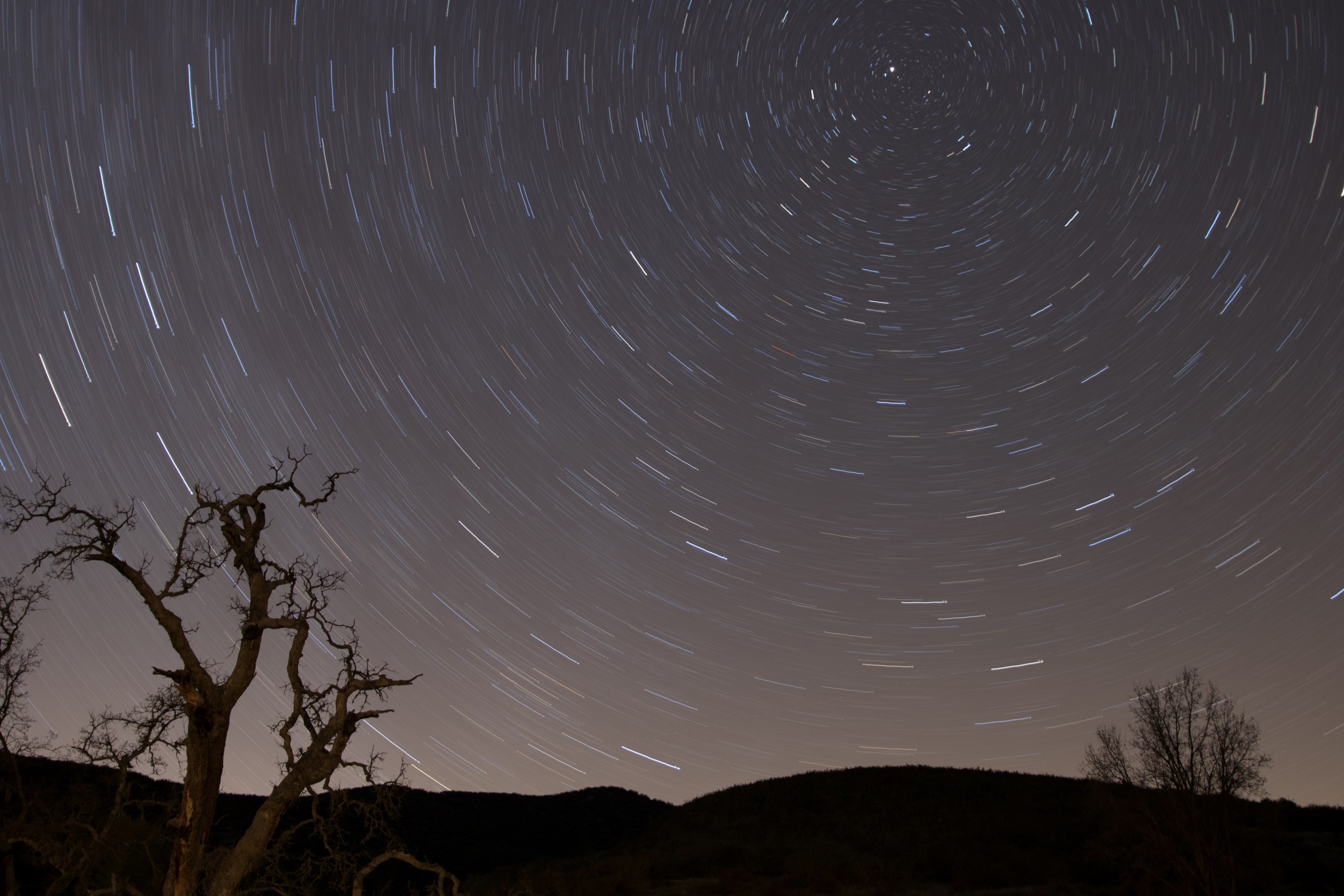 a long exposure shot of a star filled night sky featuring silhouette trees and hills, celestial adventure 4k, HD Wallpaper