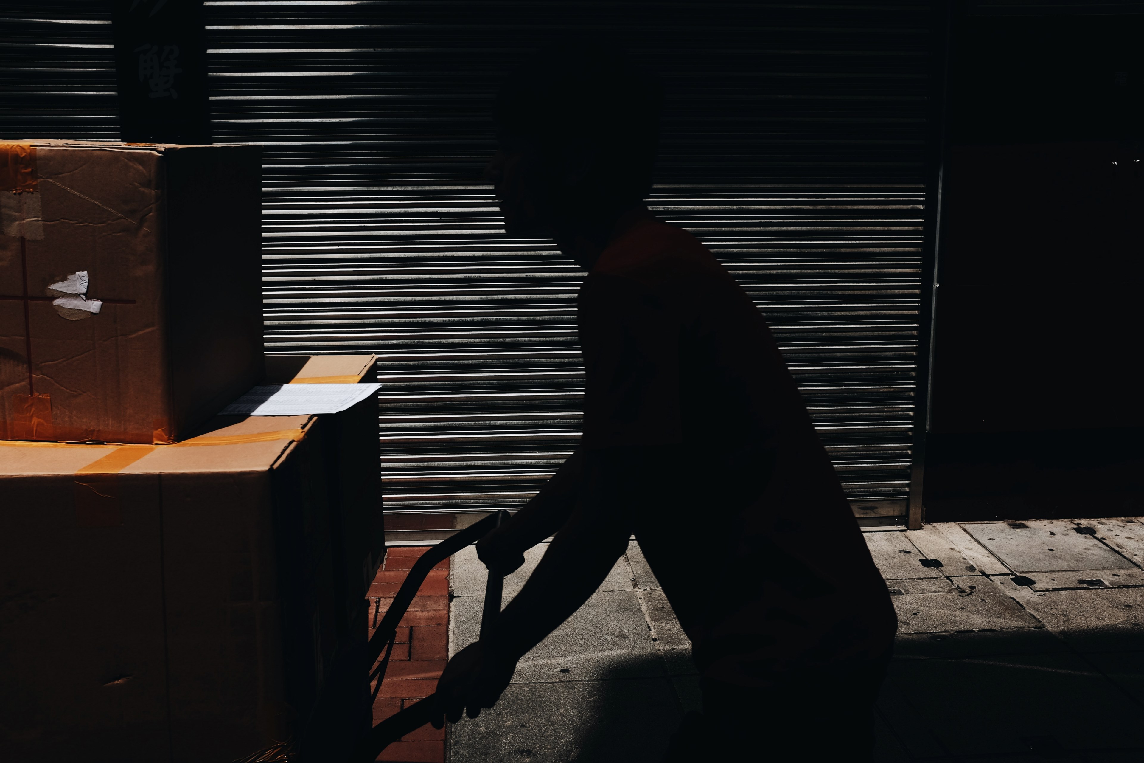a silhouette of a person pushing a cart with cardboard boxes, pushing it 4k, HD Wallpaper