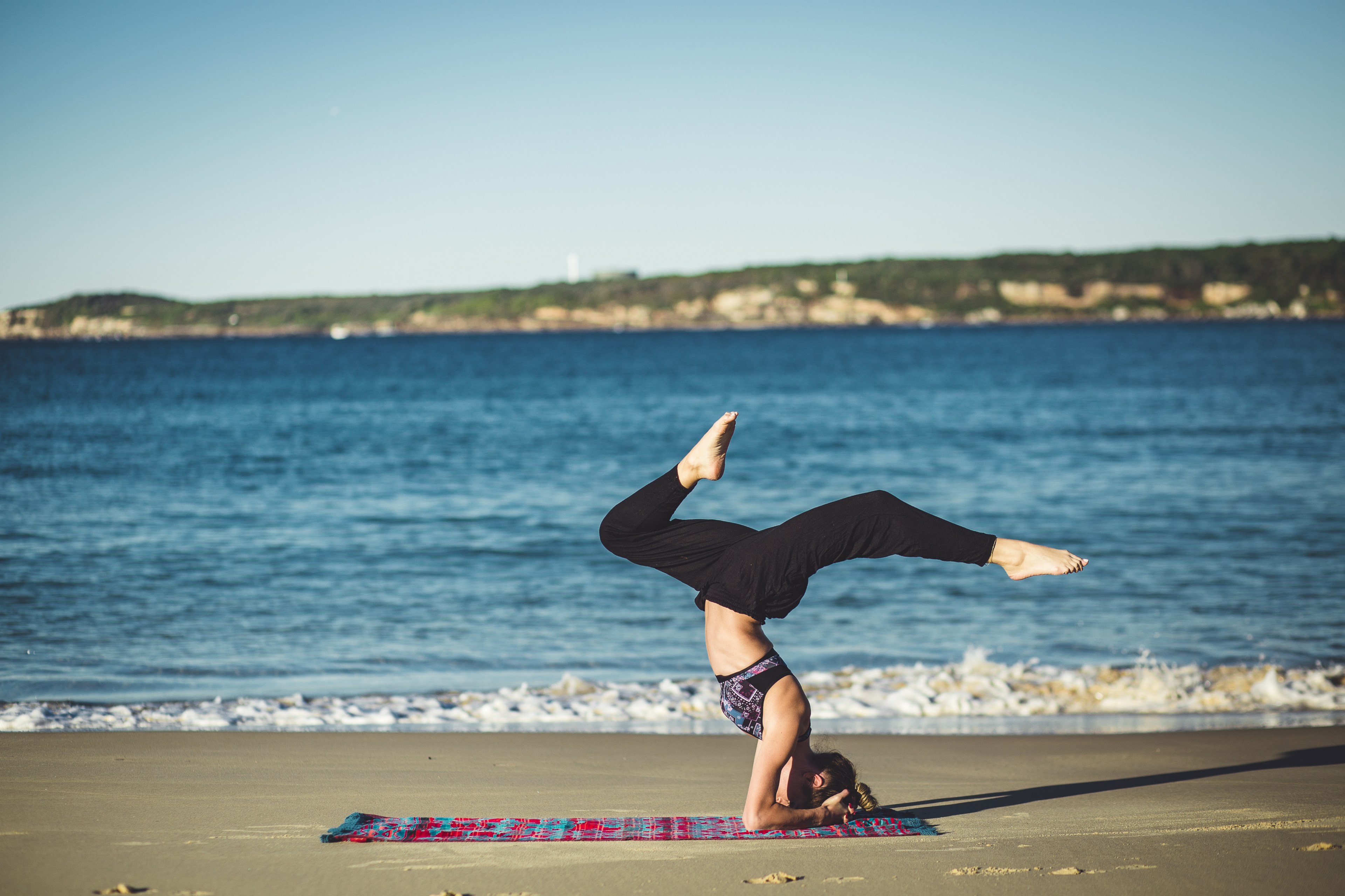 a woman doing yoga on a pink and blue yoga mat by the ocean, oceanside yoga 4k, HD Wallpaper