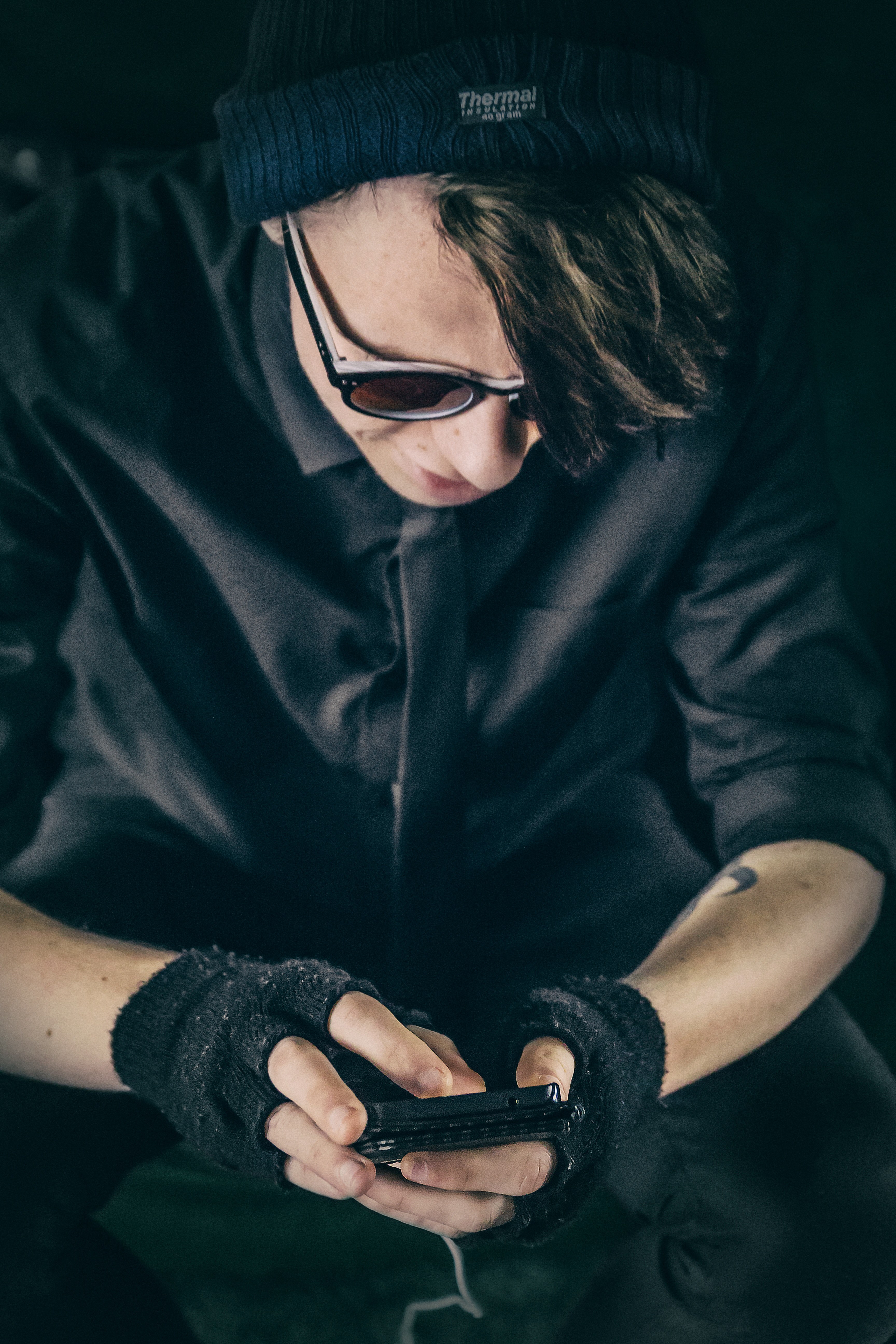 a person in black clothing and fingerless gloves looks down using an iphone, person in fingerless gloves 4k, Phone HD Wallpaper
