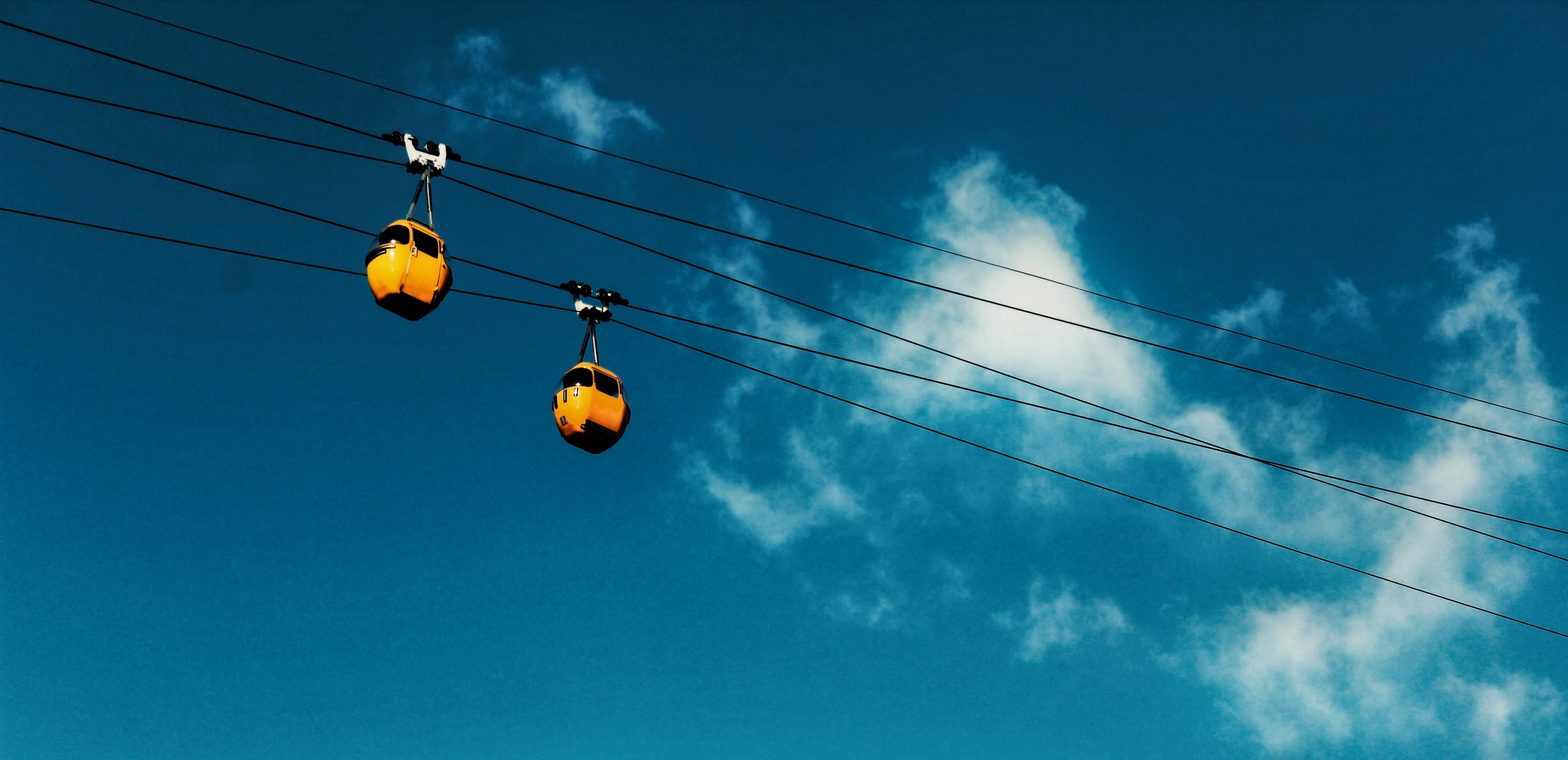 yellow cable cars ride on wires against a blue sky, riding through the sky 4k, HD Wallpaper