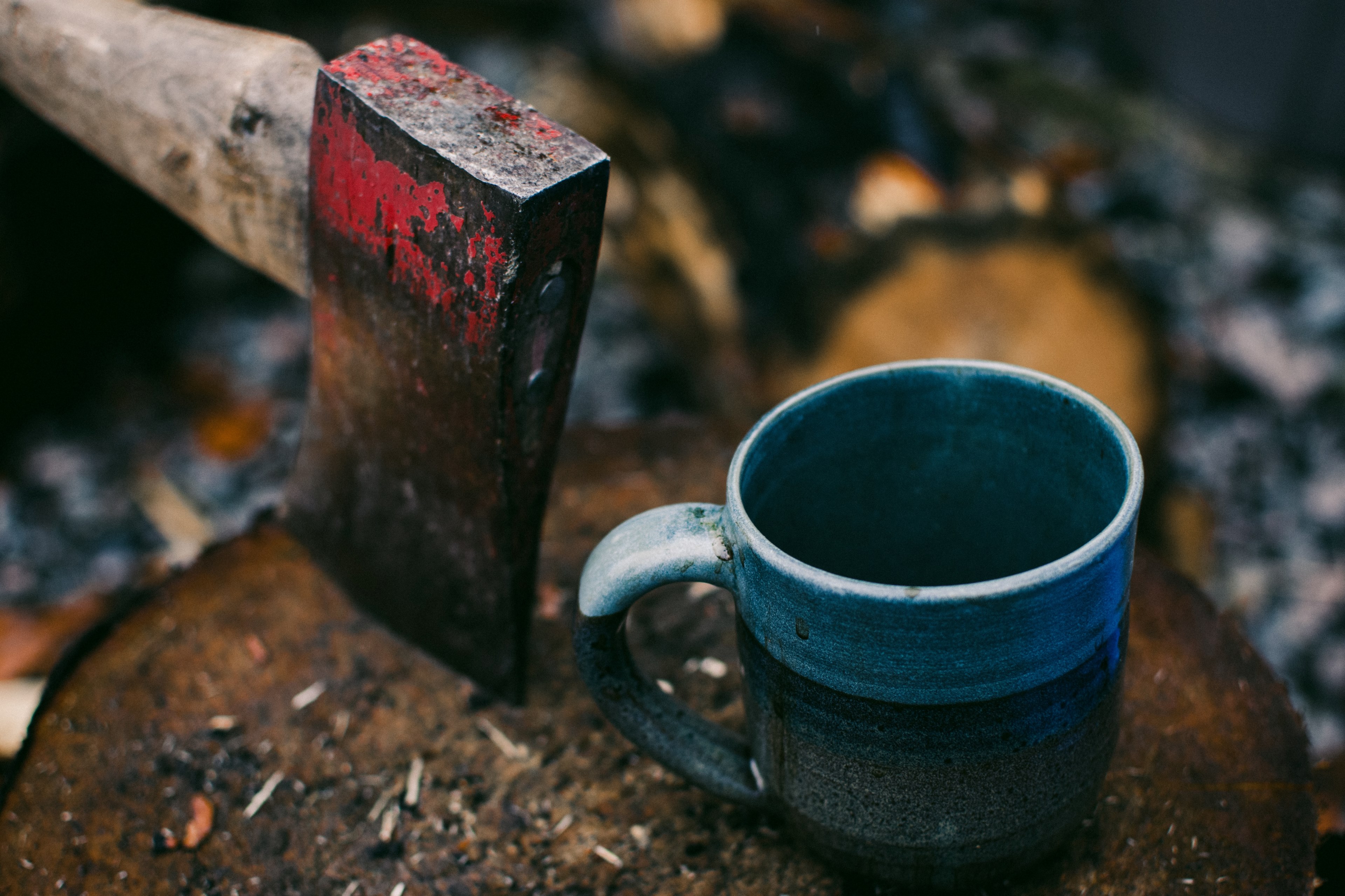 a blue enamel cup next to a rusty axe on a log, enamel cup and rusty axe 4k, HD Wallpaper