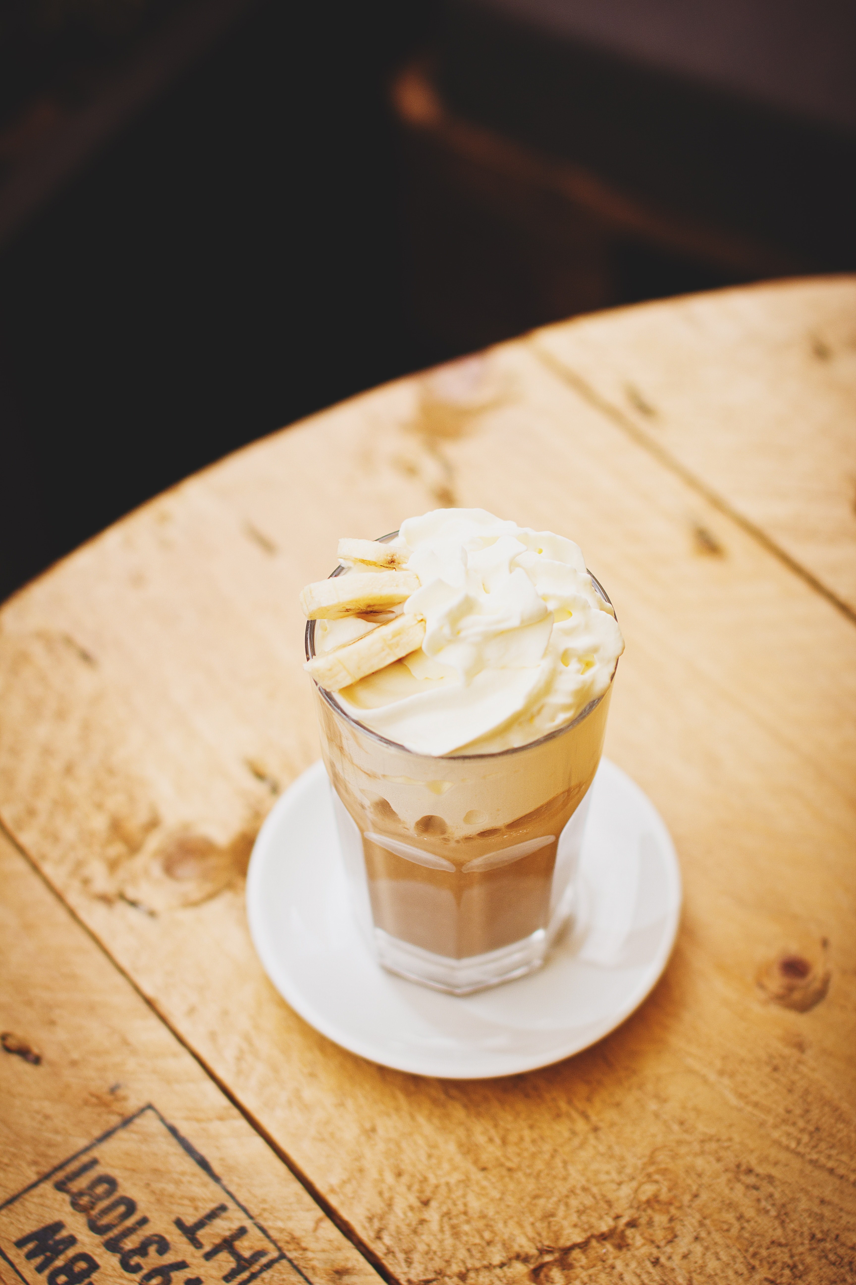 coffee drink with whipped cream and banana sits on a cafe table, sweet coffee drink 4k, Phone HD Wallpaper