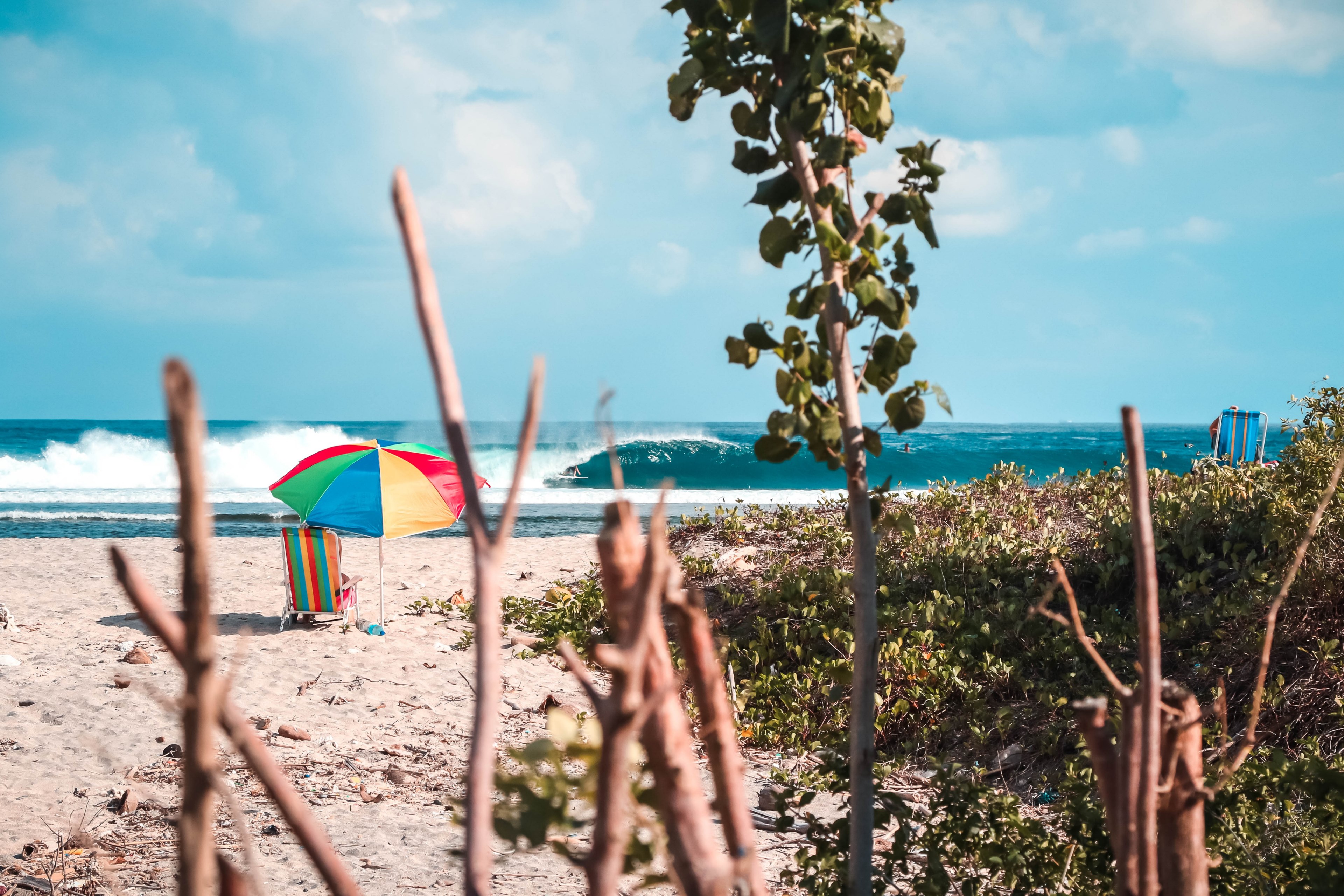 beach sun umbrella with beach chair on the sand beach overlooking a surfer surfing in lombok, looks like heaven 4k, HD Wallpaper