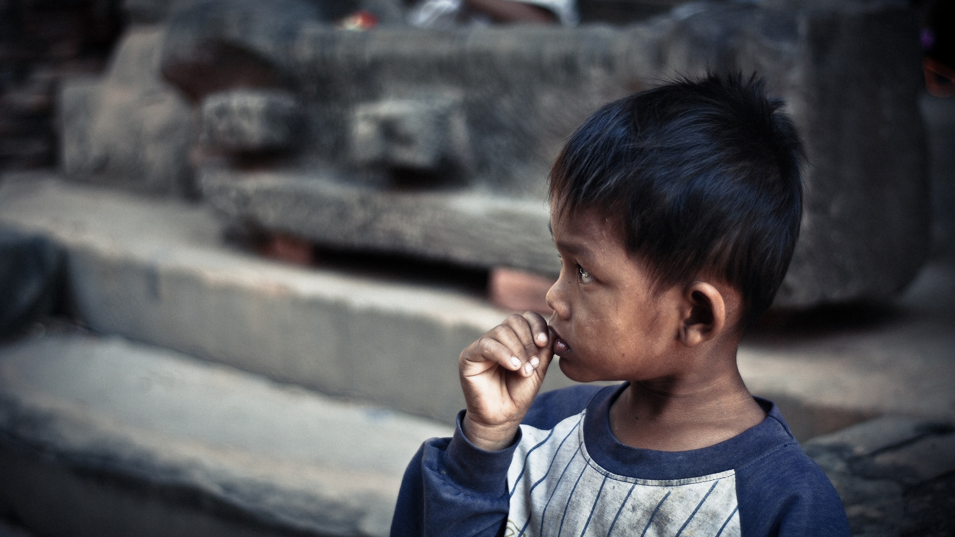 a young boy with his hand in his mouth in front of steps at angkor wat, boy at angkor wat 4k, HD Wallpaper