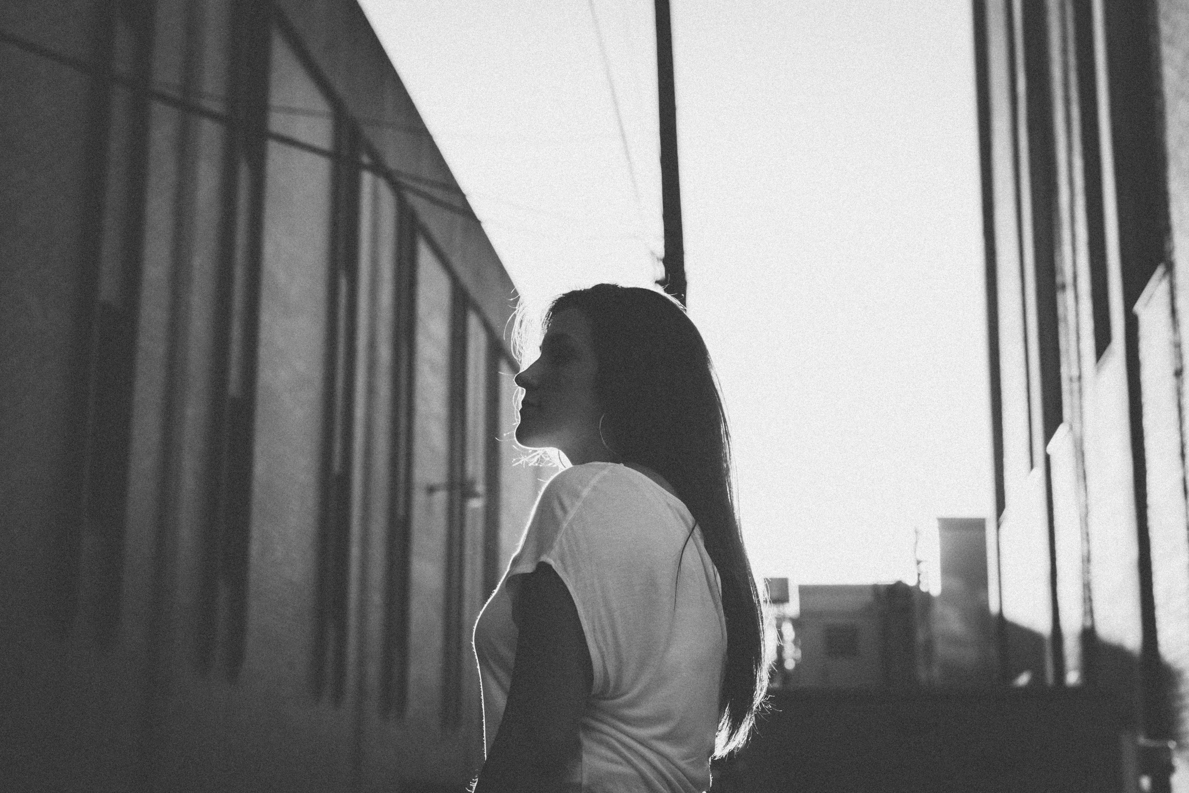 pensive woman in black and white stands between buildings, between buildings 4k, HD Wallpaper